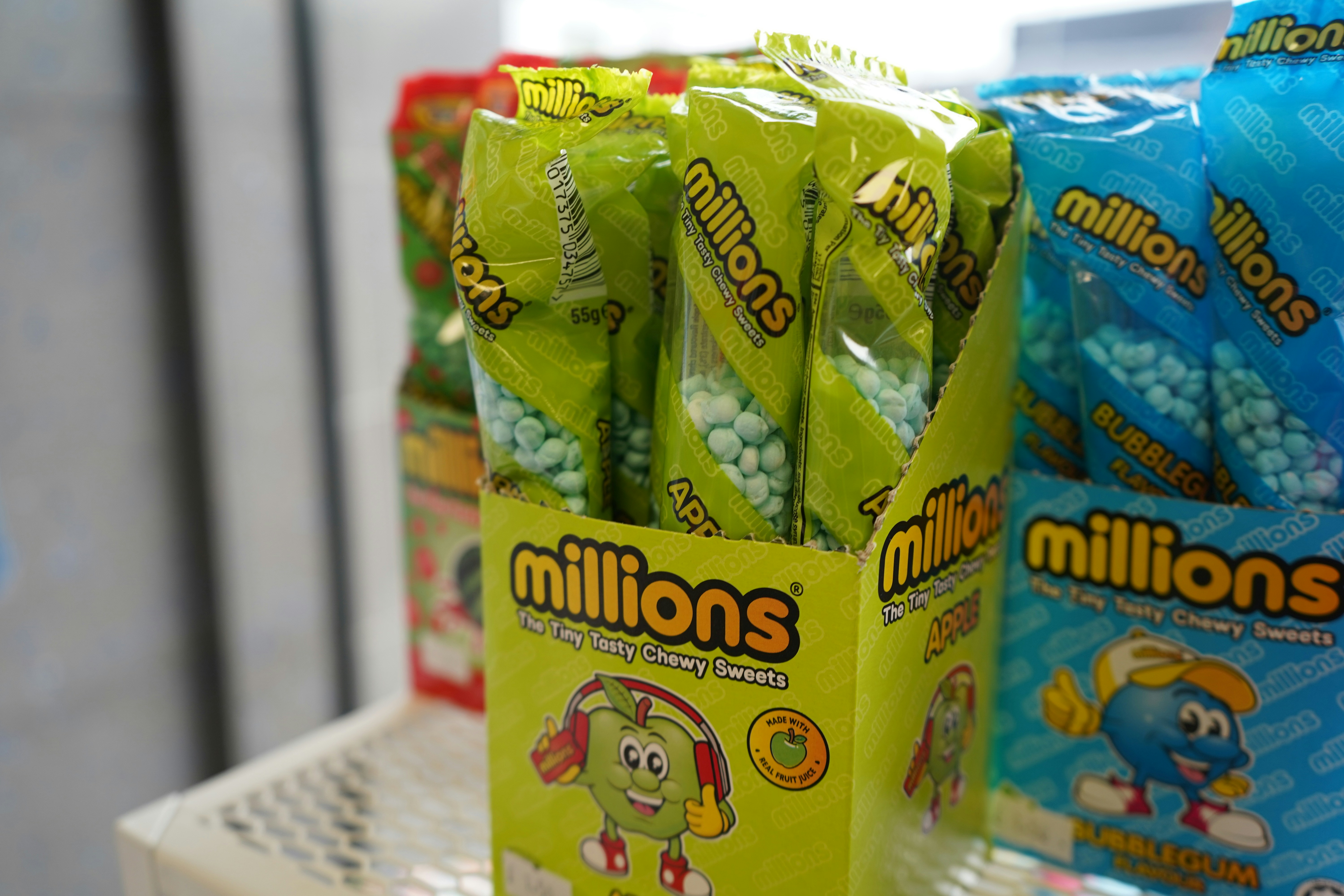 Green and blue candy packets with 'millions' logo