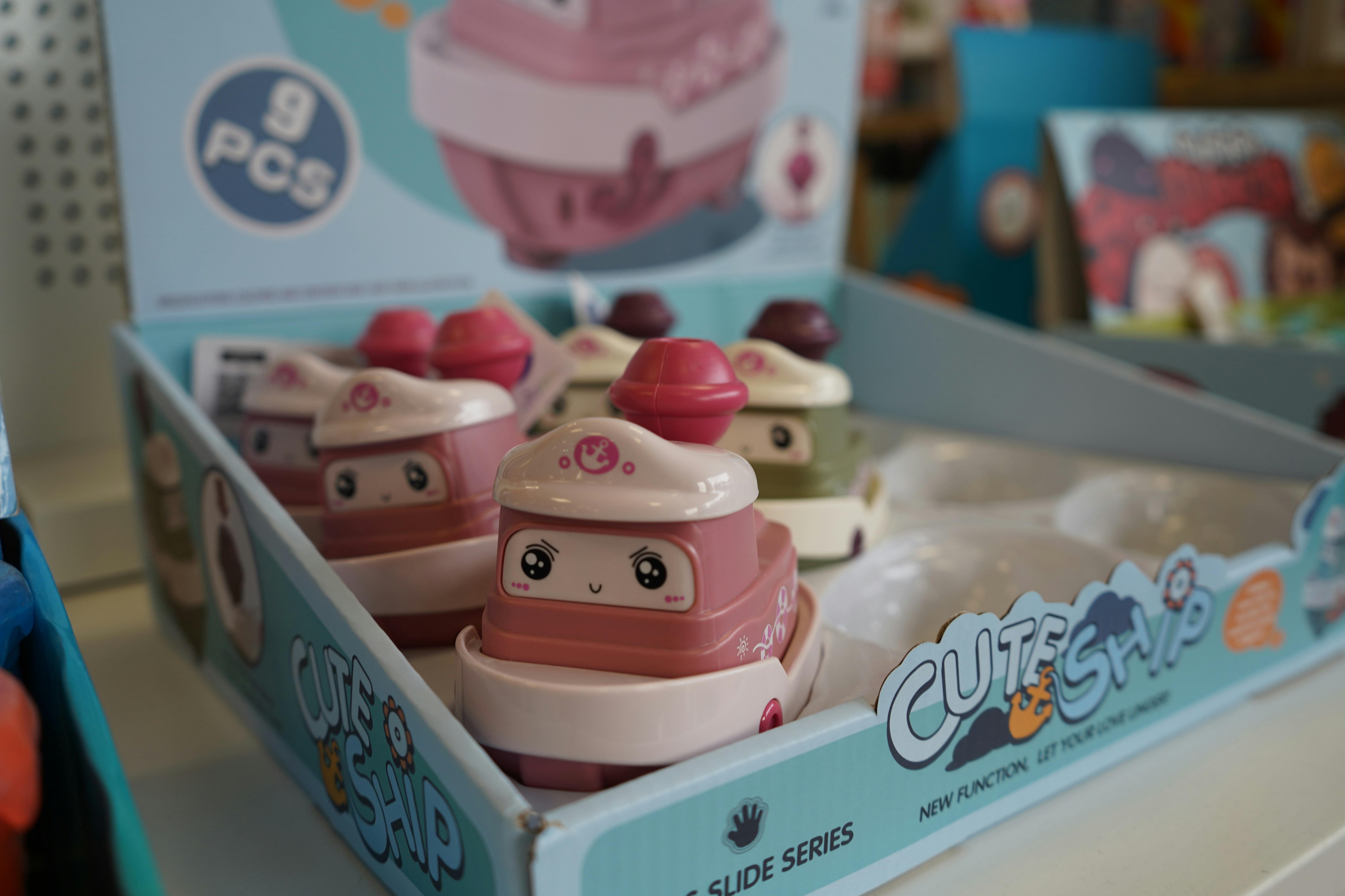Several cute toy boats displayed in a box.