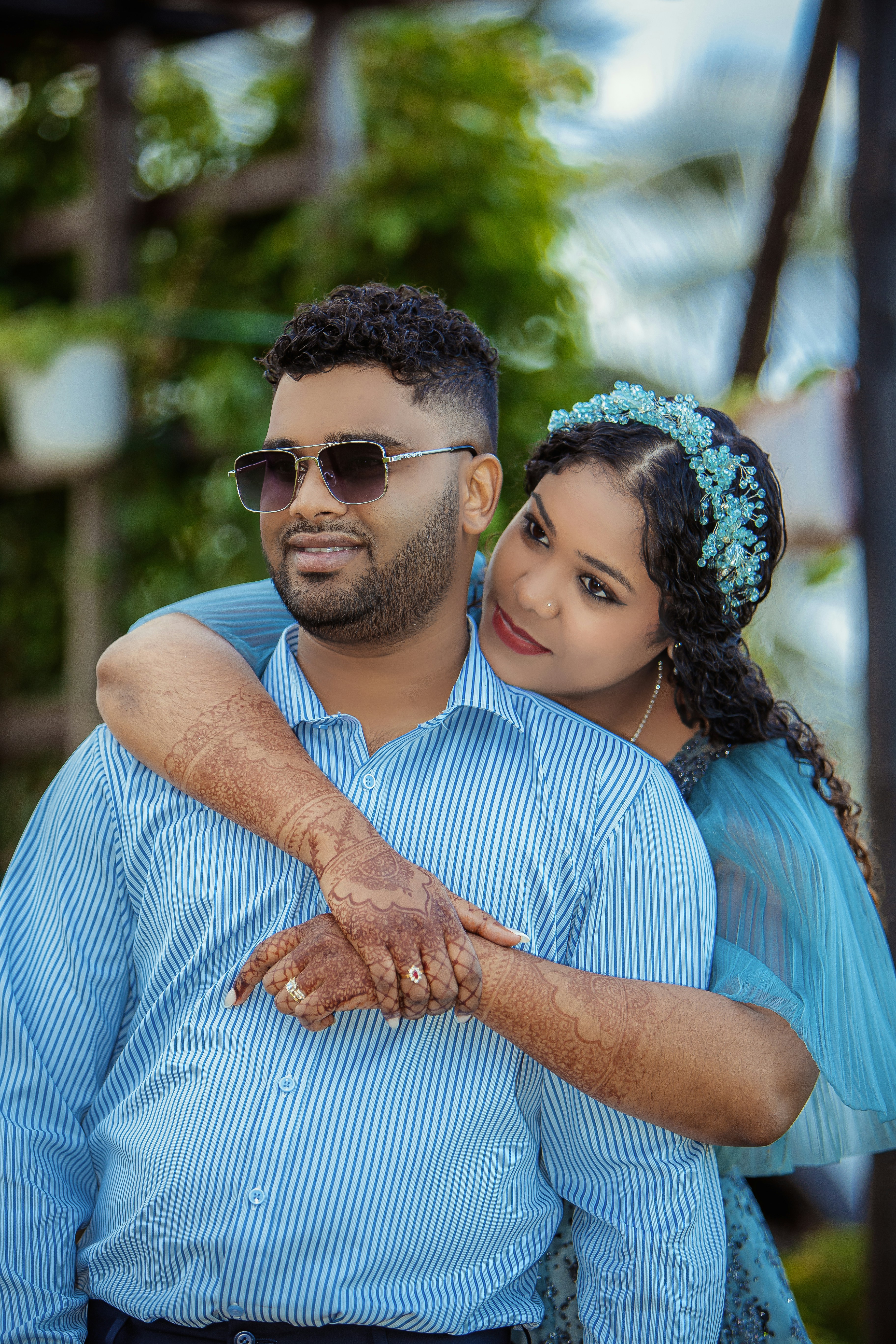 A couple embracing outdoors with a blurred background