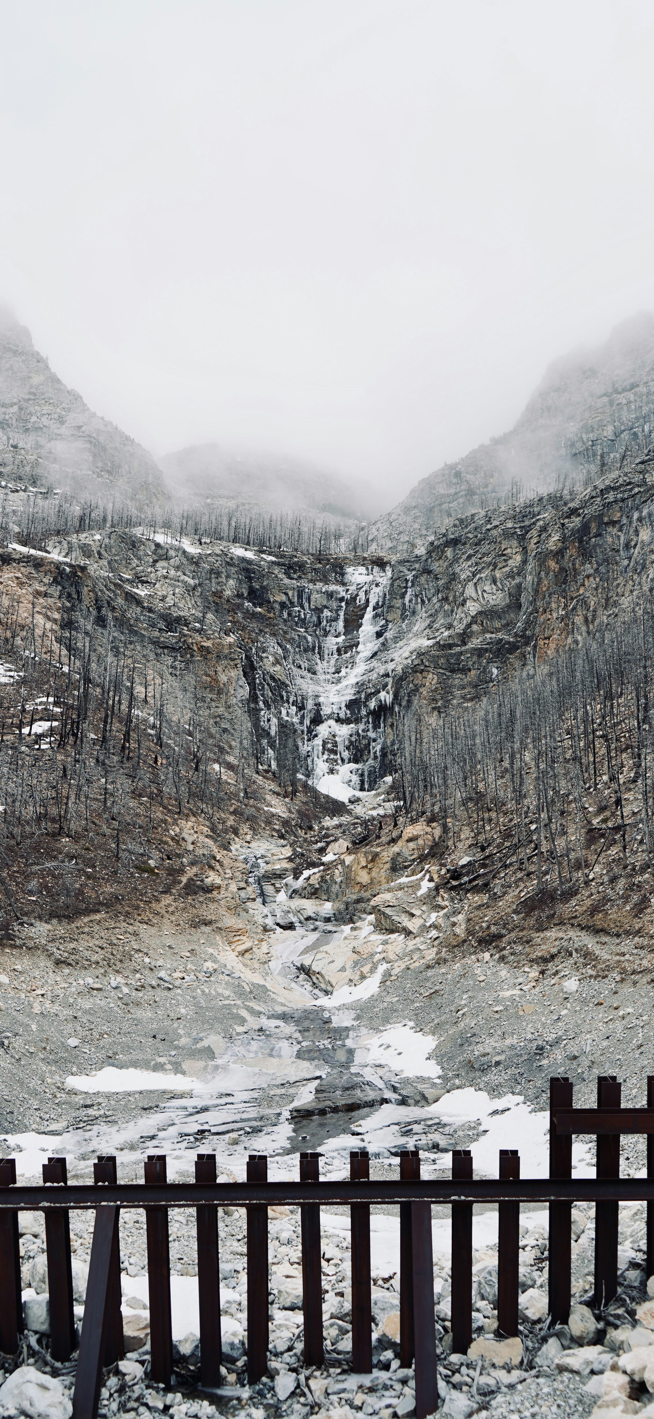 Ein gefrorener Wasserfall, der einen felsigen Berghang hinunterstürzt.