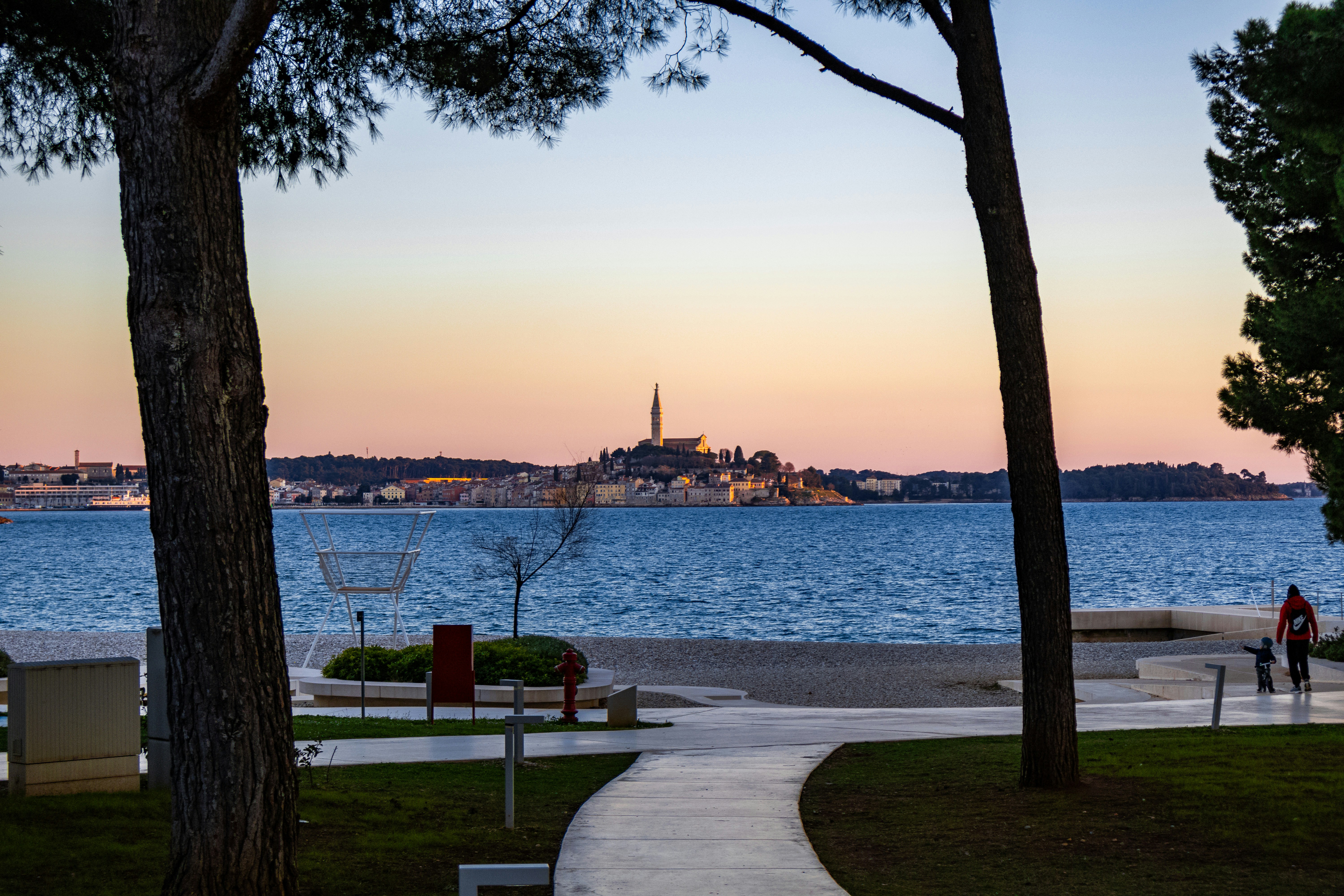 Coastal town skyline across the blue ocean at sunset.