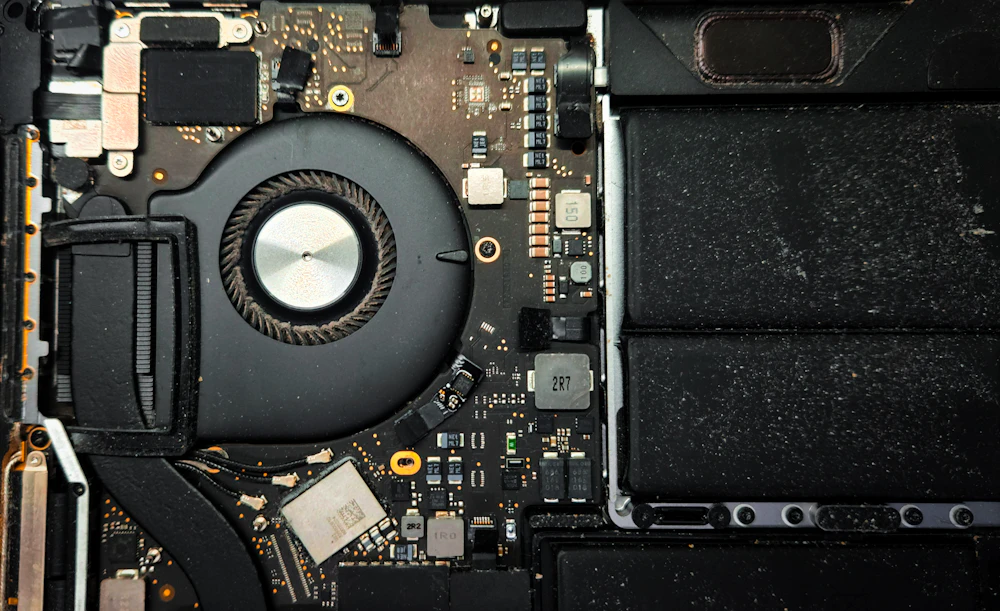 Inside a MacBook Pro, showing the logic board and cooling fan