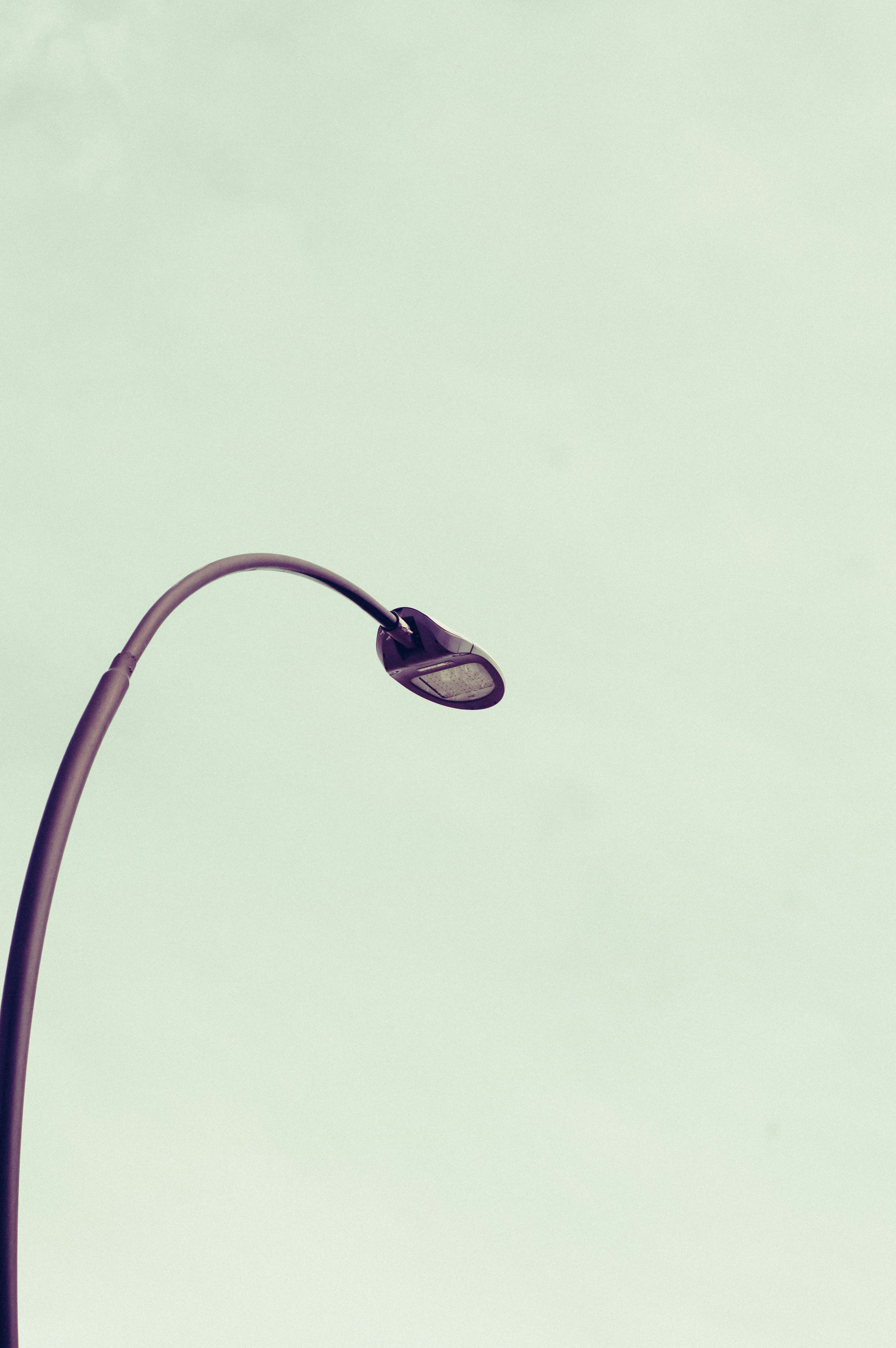 Eine einsame Straßenlaterne vor einem blassen Himmel