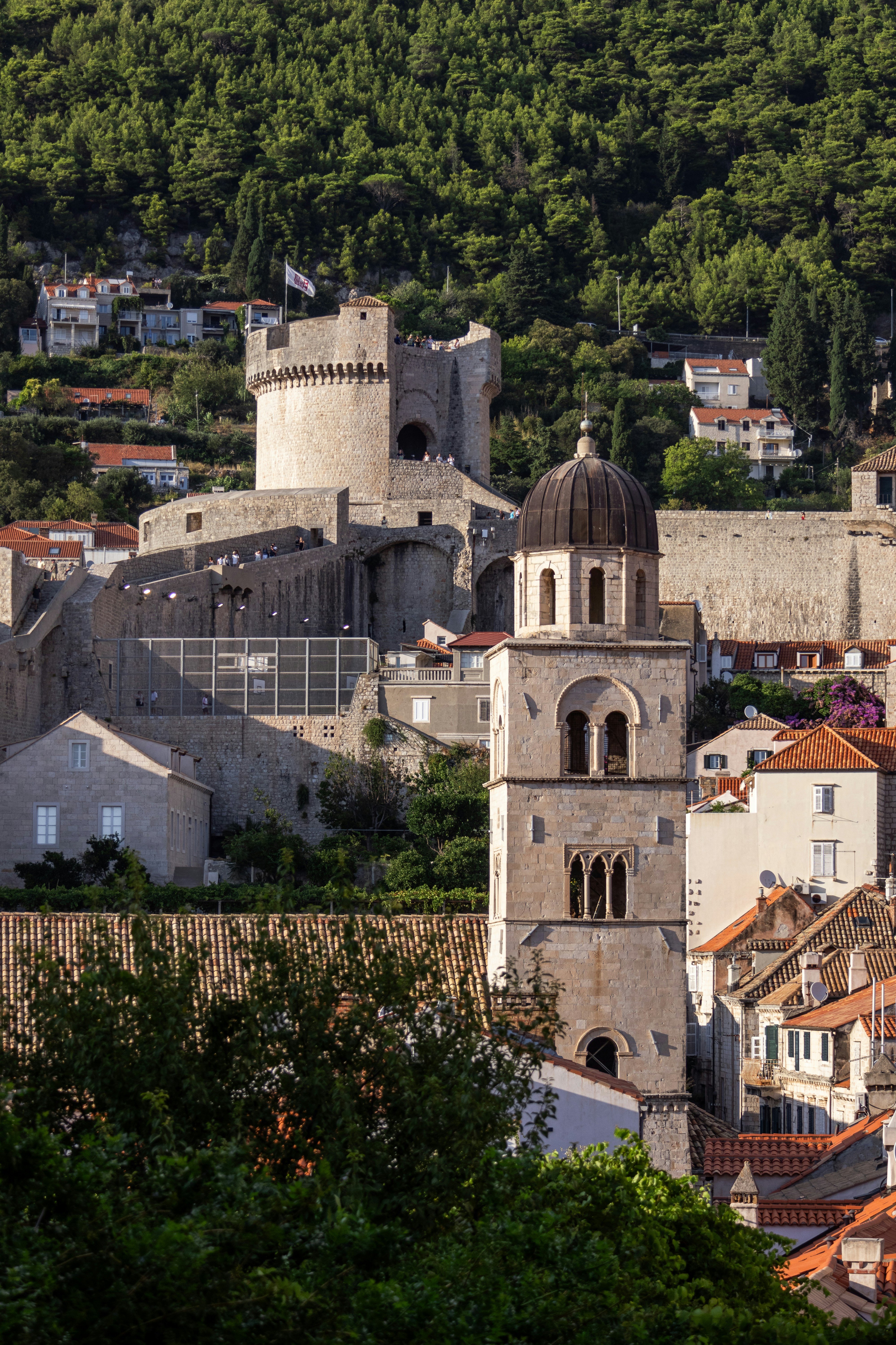 Historic stone tower and castle on a green hillside.