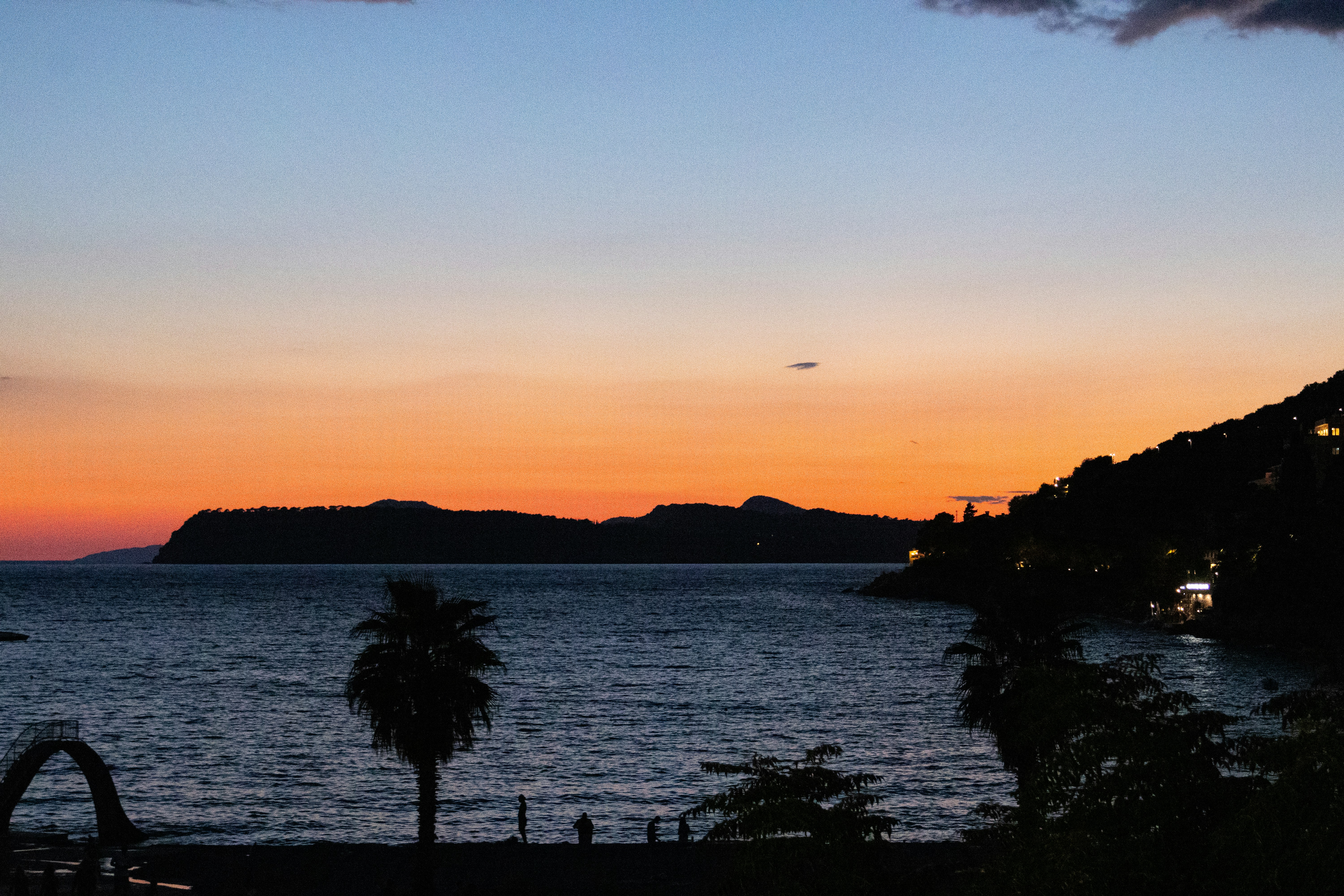 Sunset over the ocean with a distant island.