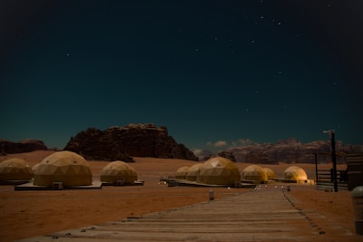 Desert encampment with dome tents under starry night sky