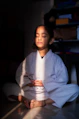 Young girl in white gi meditating with eyes closed.
