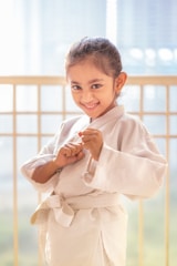 A smiling young girl in a karate uniform