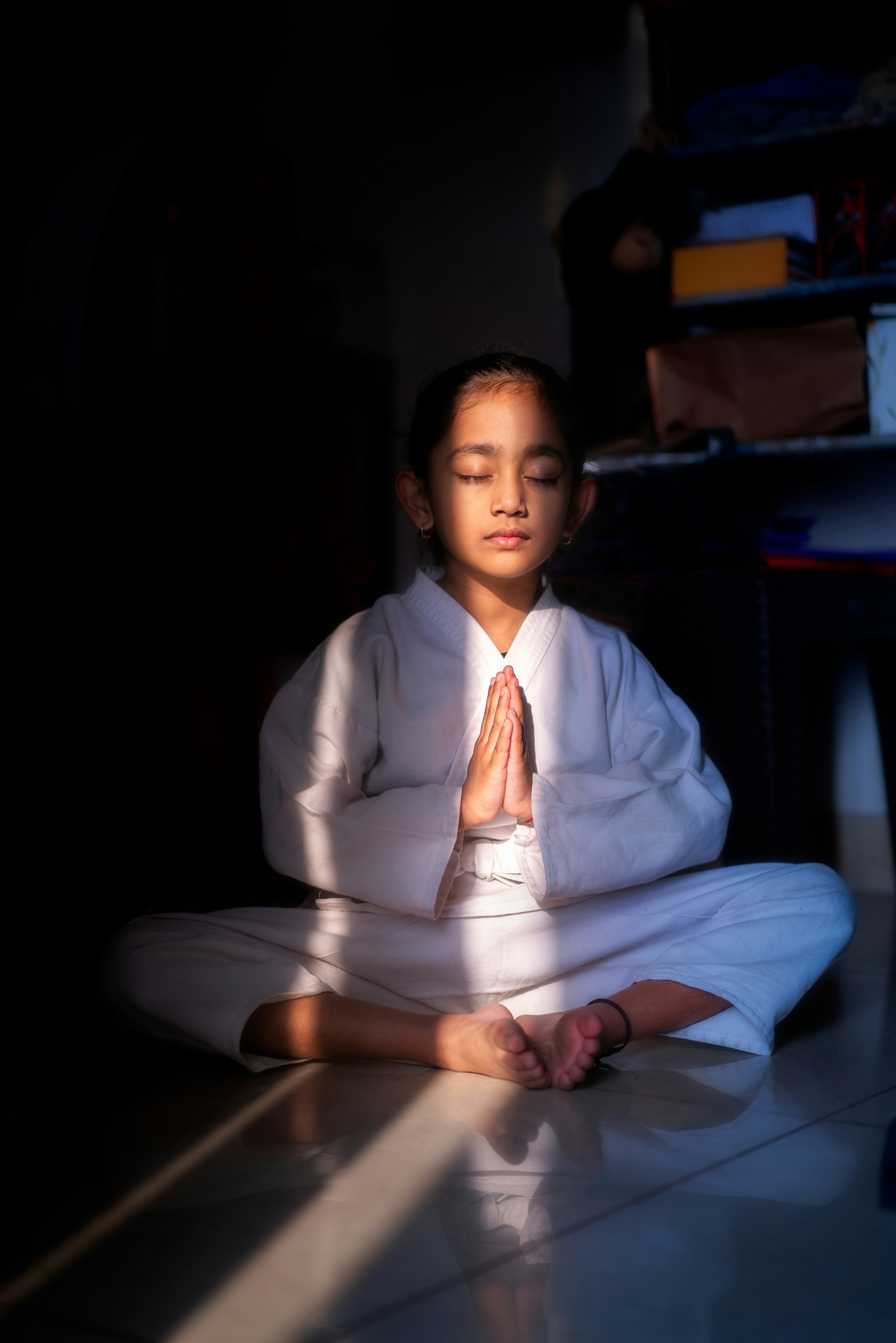 Young girl meditating with hands clasped in prayer