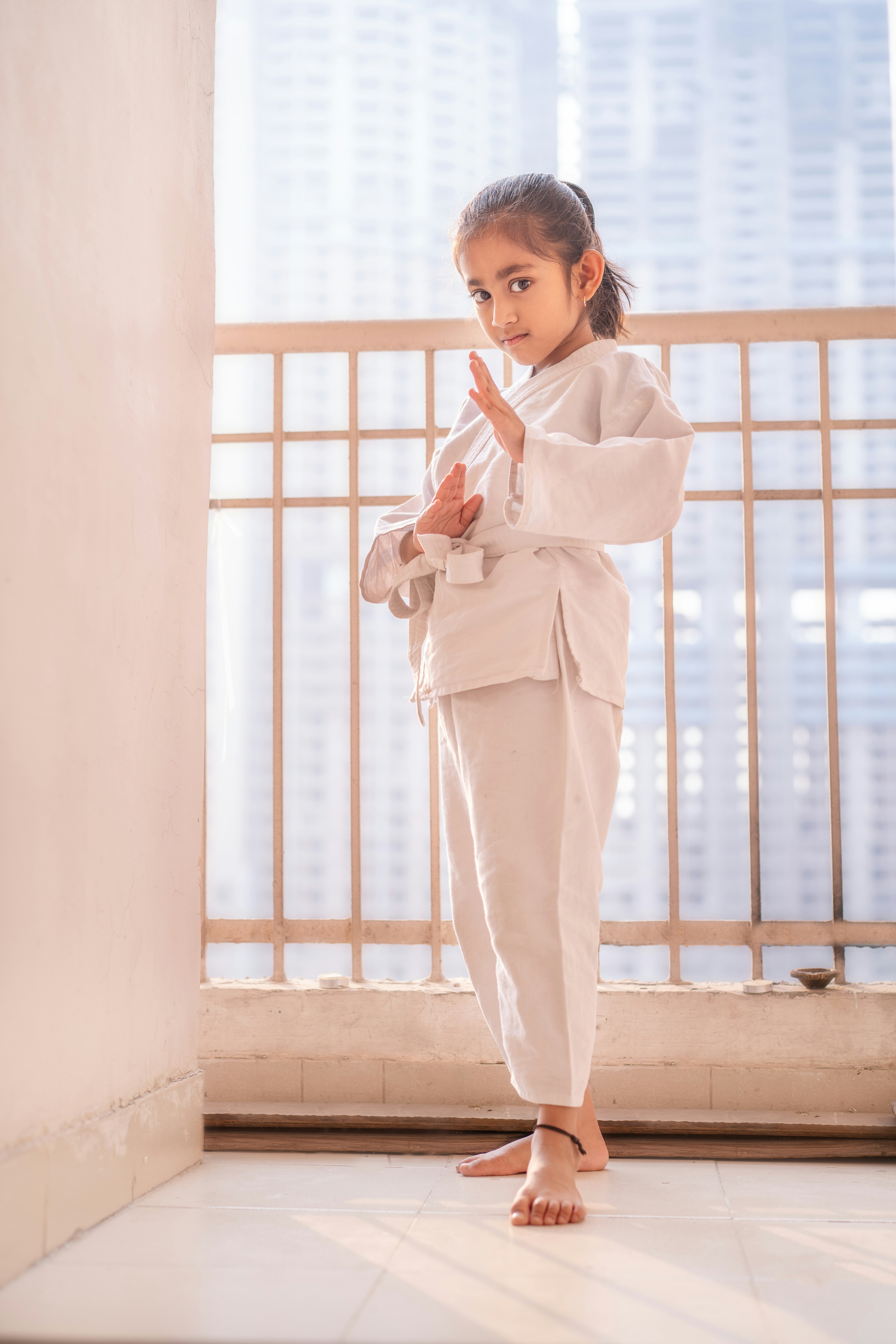 Young girl in white karate uniform practicing a stance.