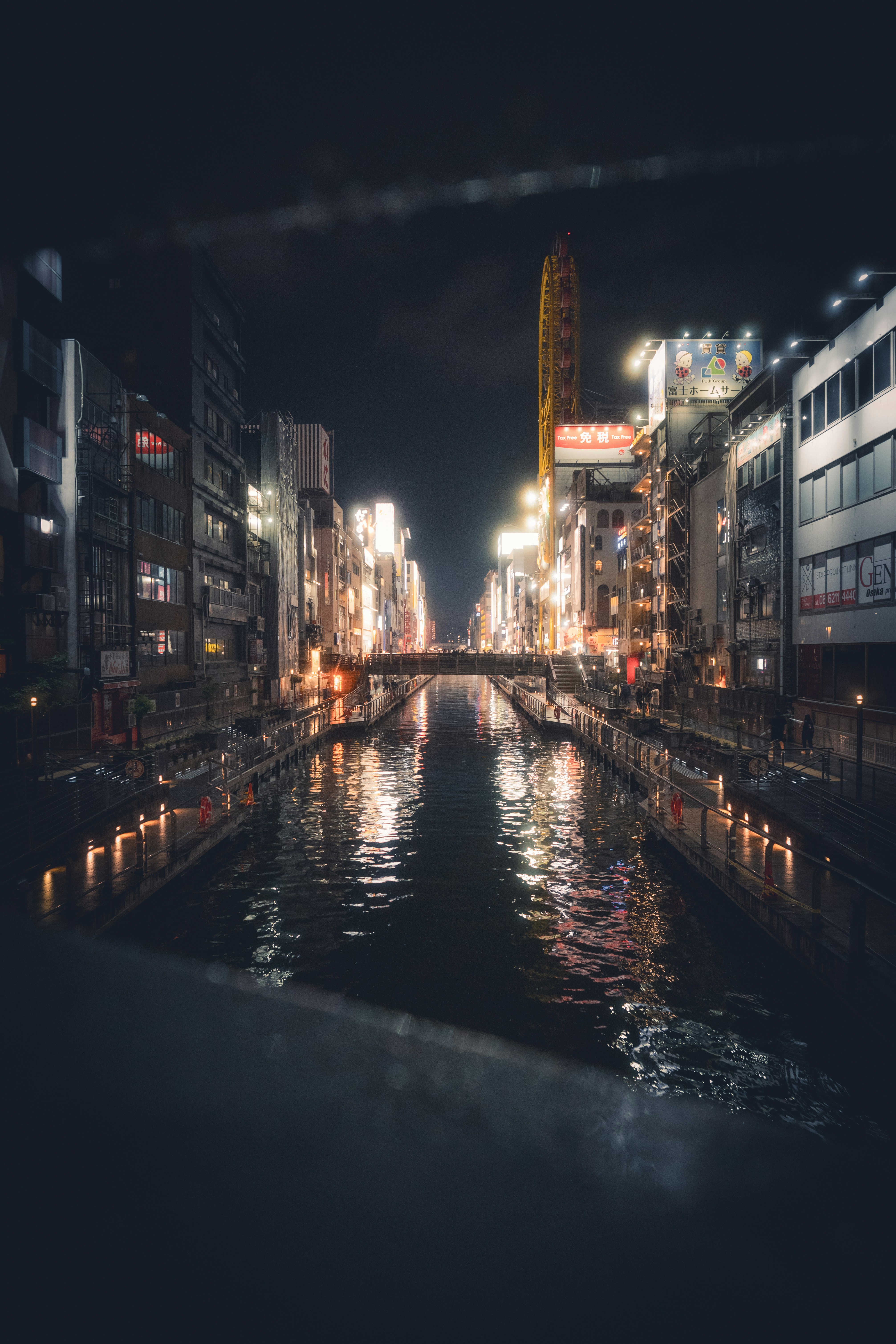 City canal at night with illuminated buildings and reflections.
