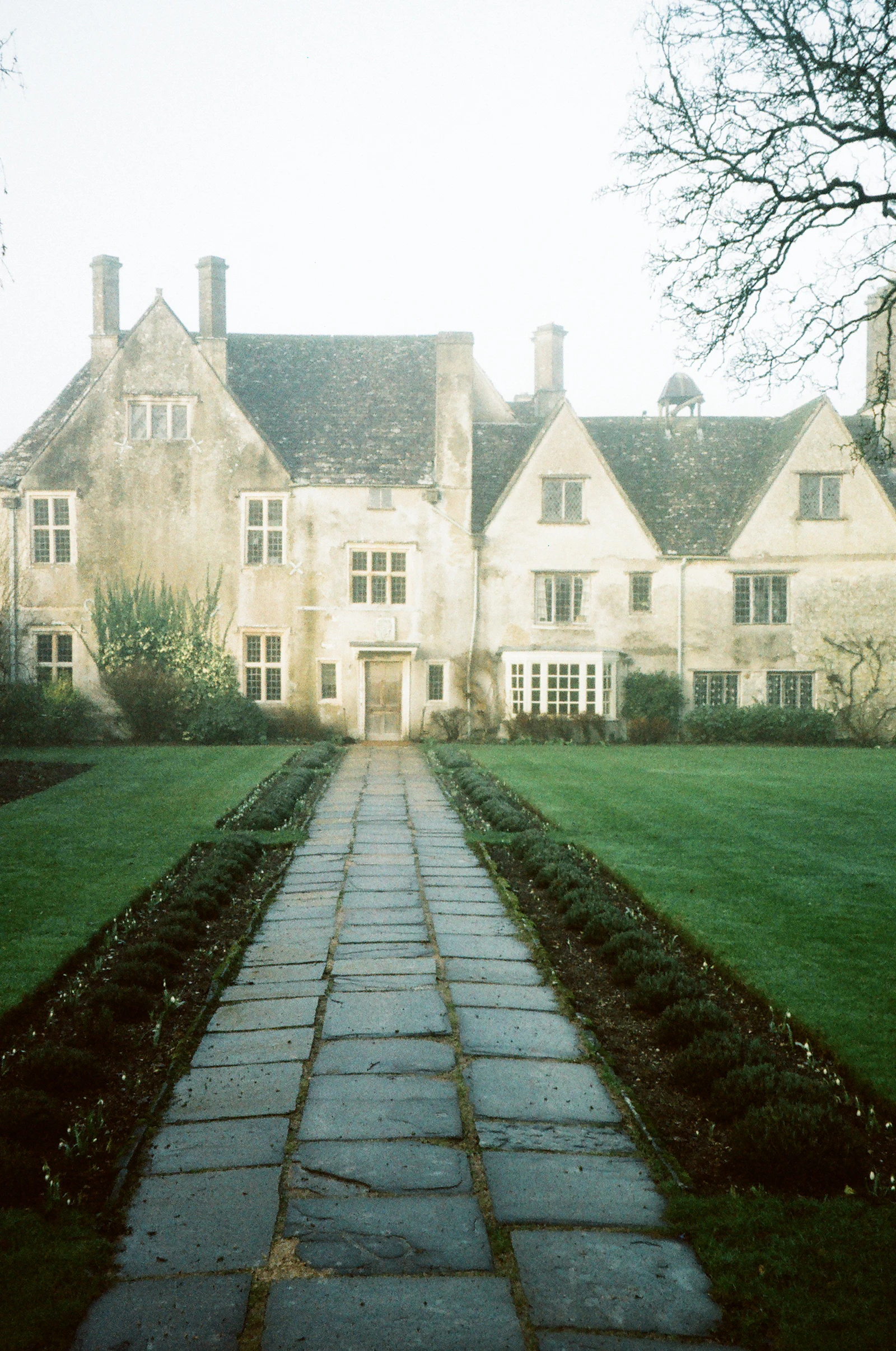 A stone walk crossing the front lawn of an old house