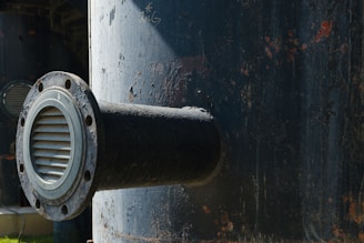 Close-up of a rusty industrial pipe with a vent.