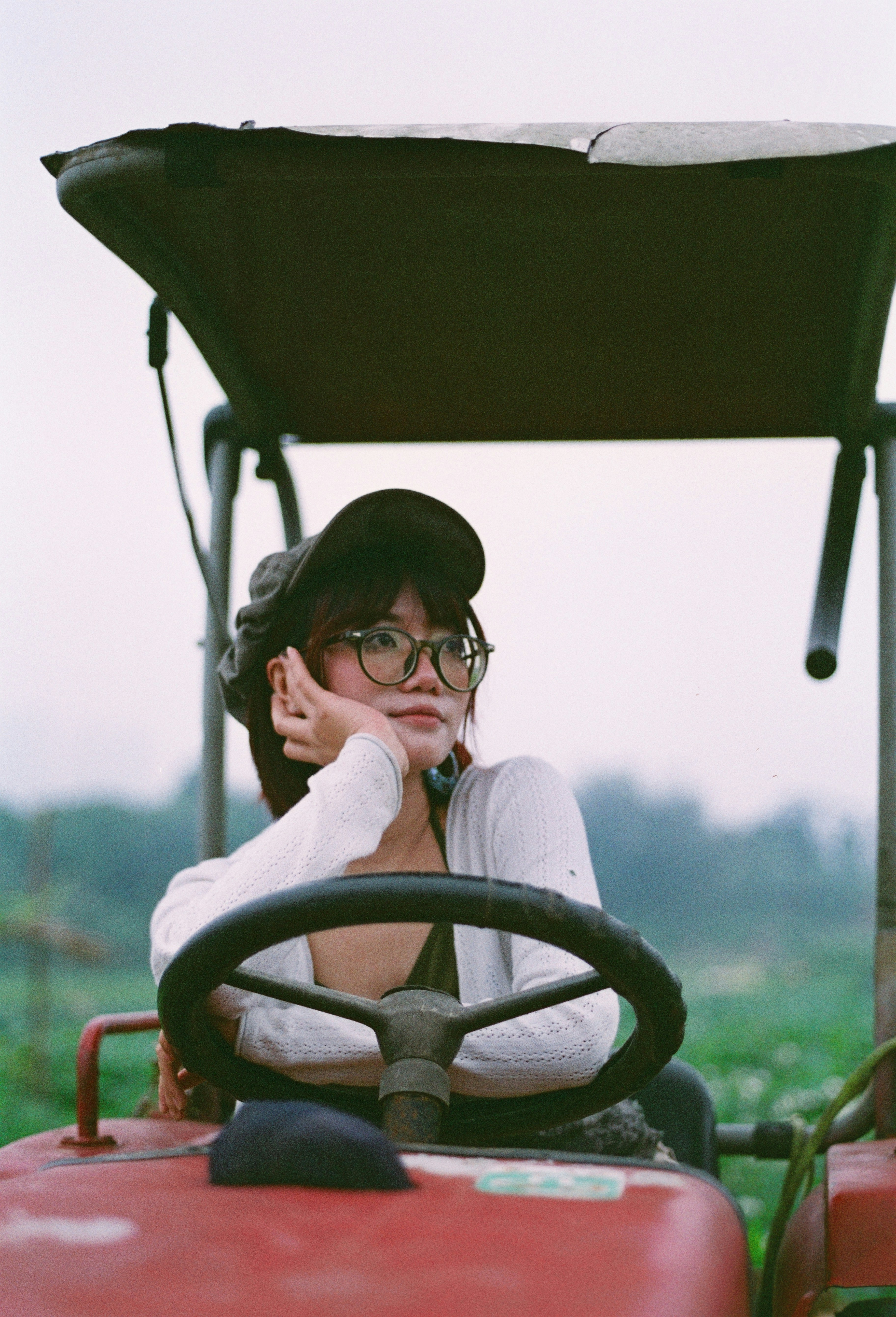 Jeune femme portant des lunettes et un chapeau sur un tracteur