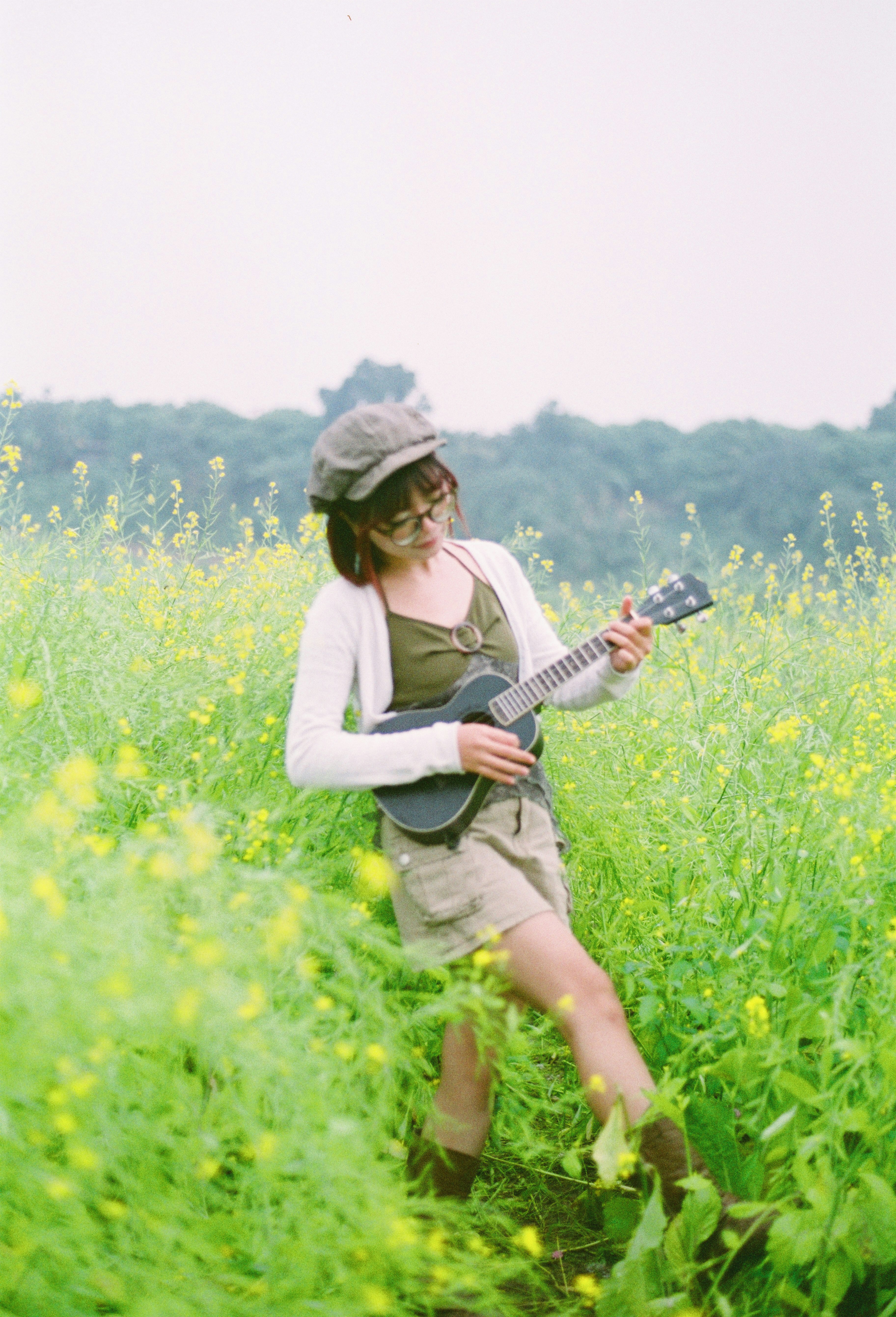 Jeune femme jouant du ukulélé dans un champ de fleurs jaunes
