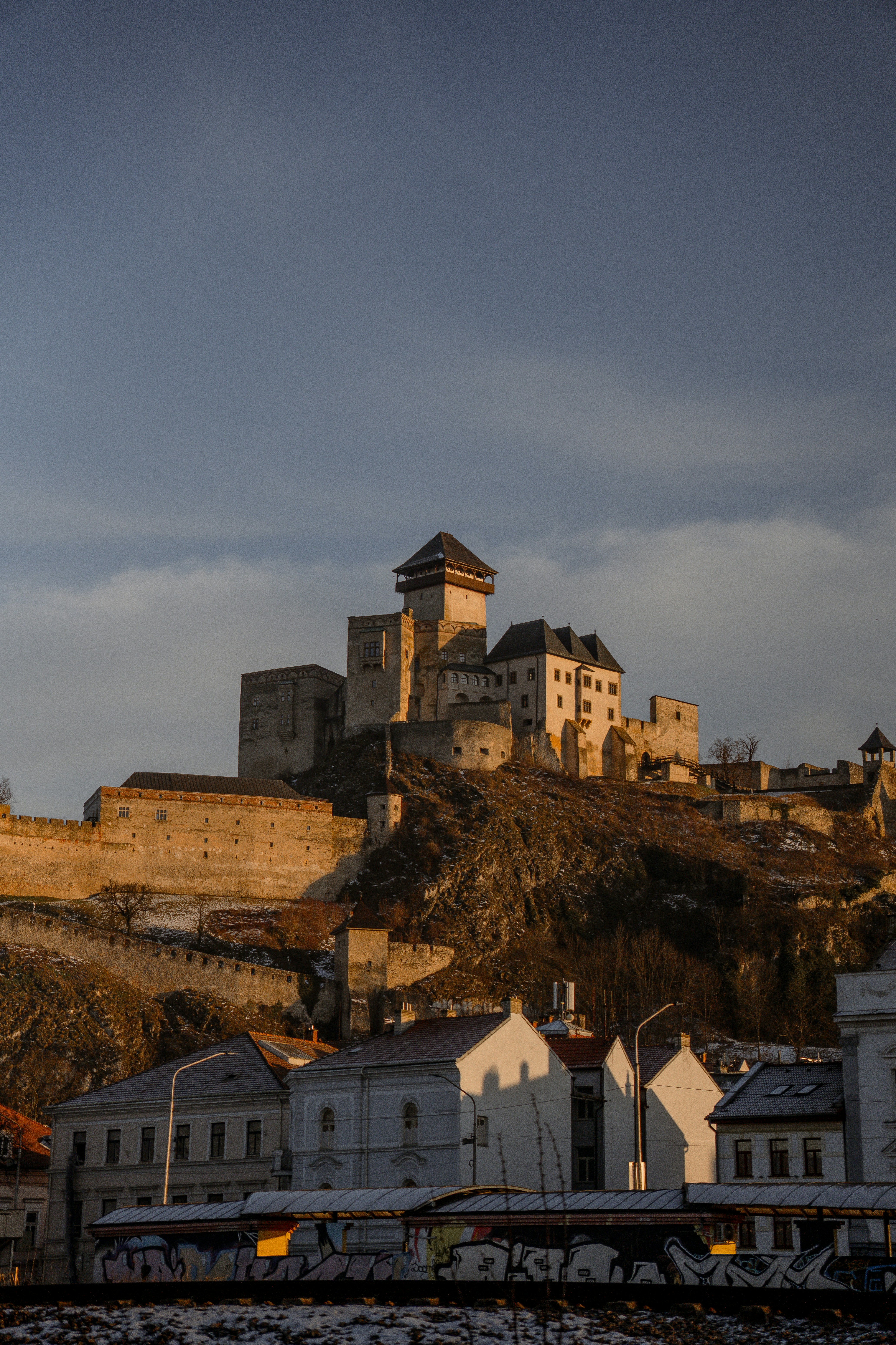 Castle on a hill at sunset with town below