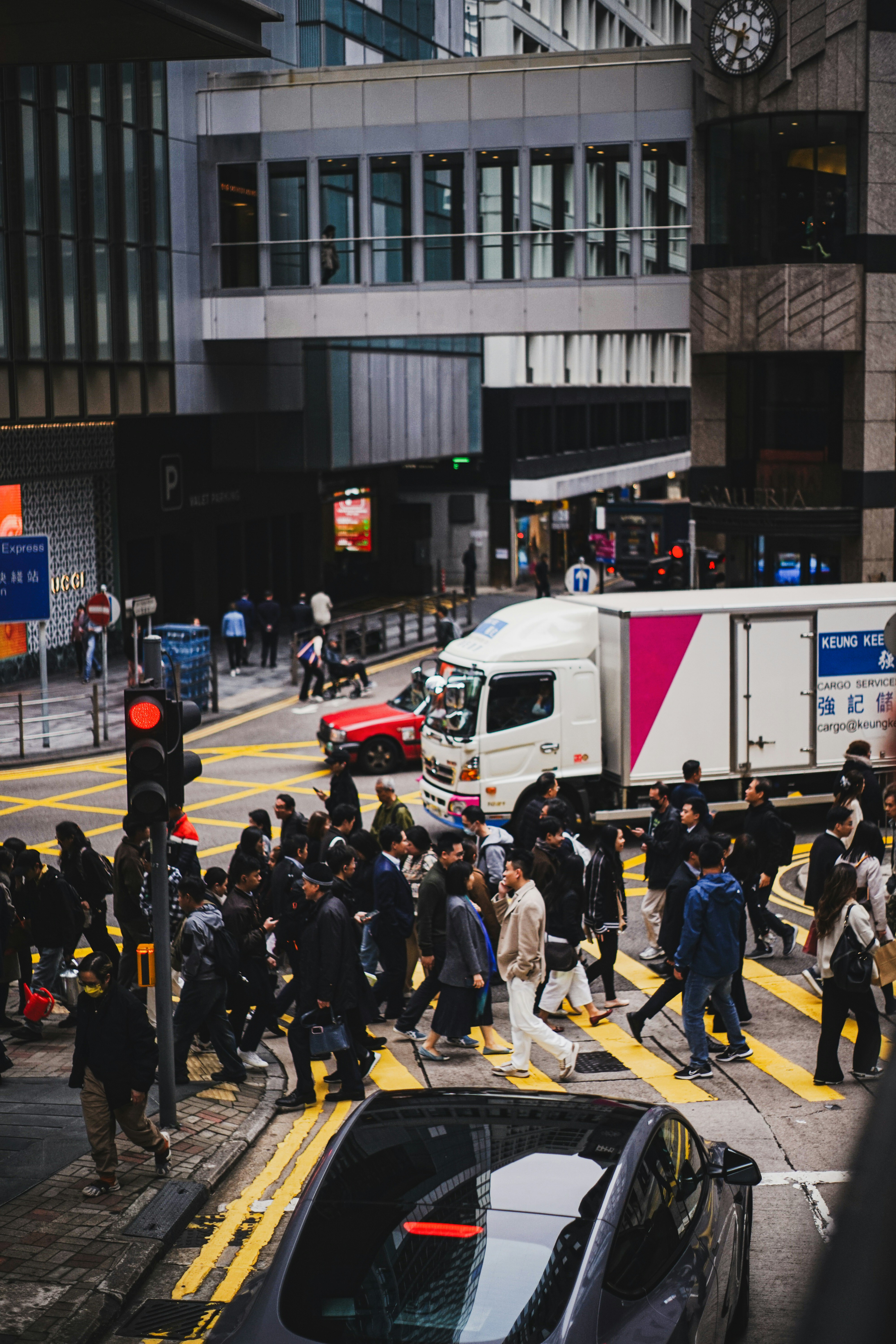Crowded city street with pedestrians crossing at intersection.