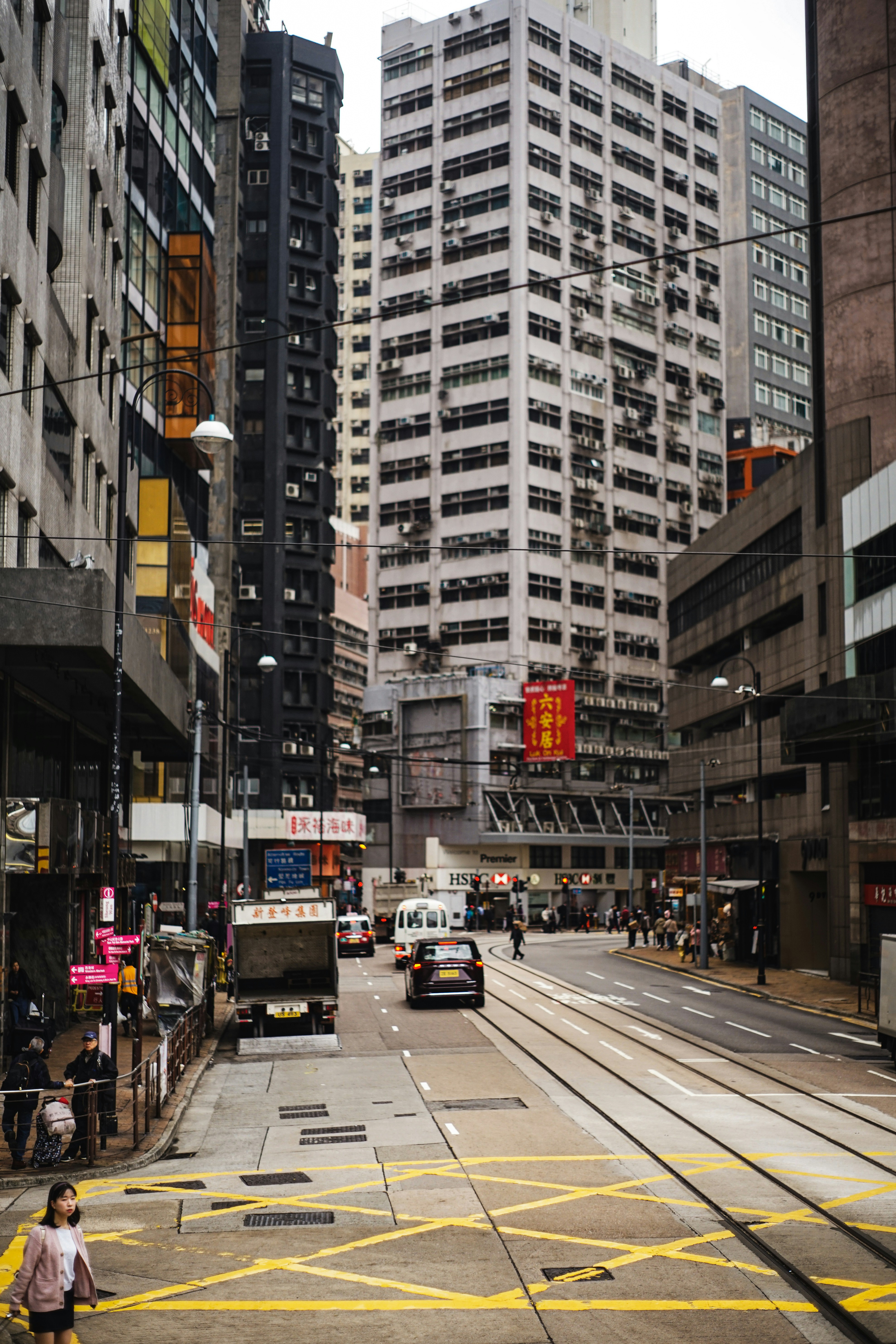 Busy city street with tram tracks and tall buildings