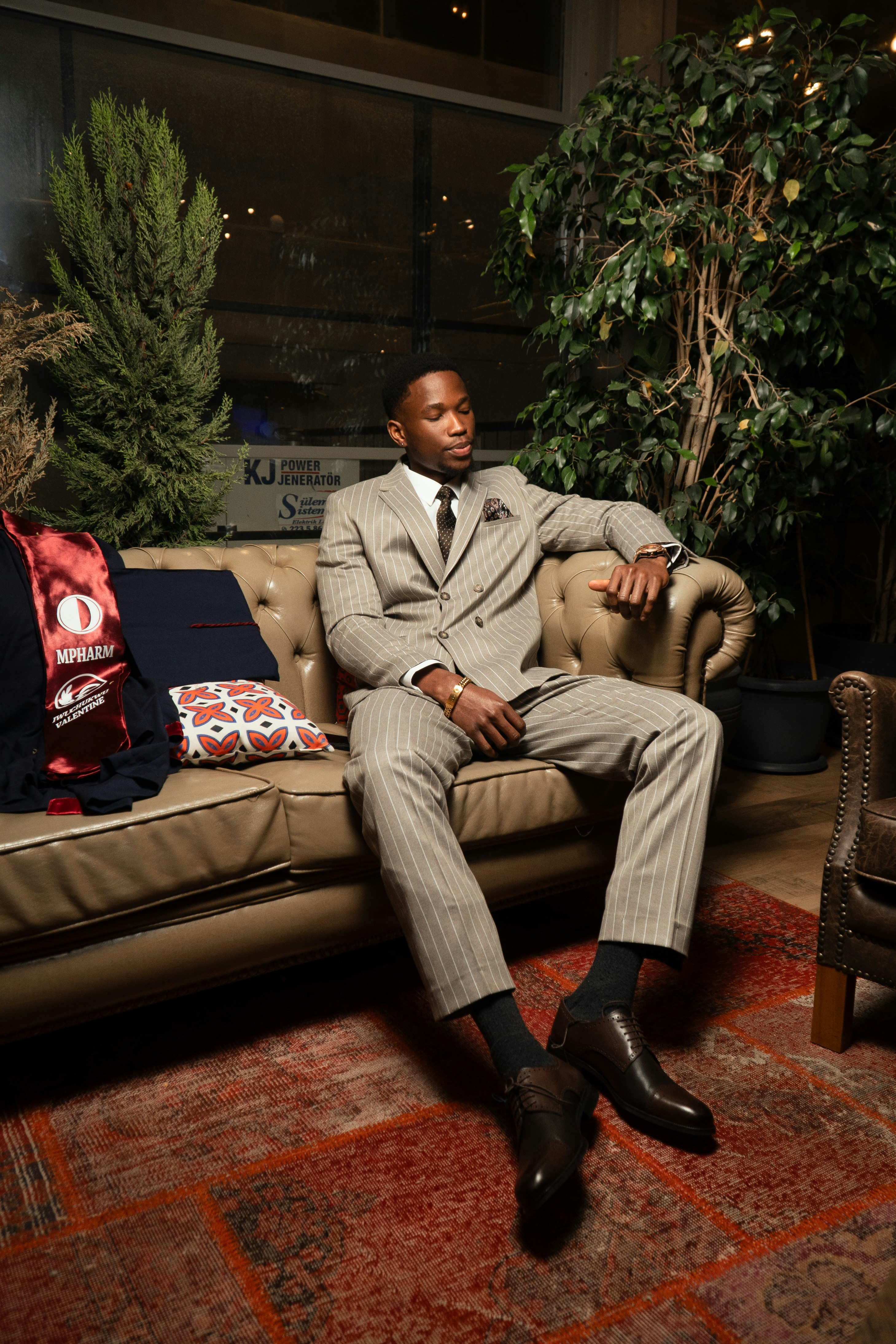 Hombre con traje de rayas sentado en un sofá de cuero