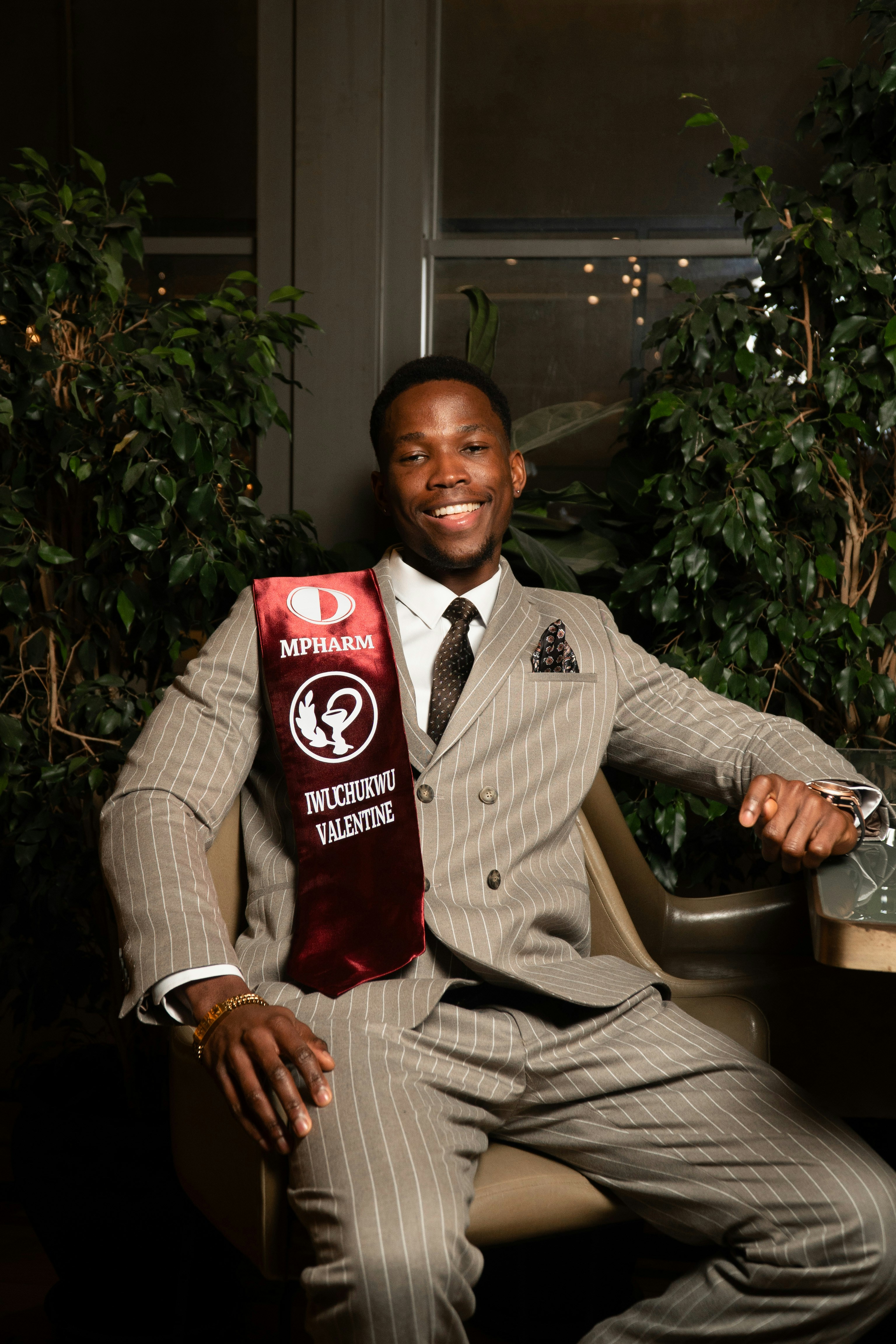 Un hombre sonriente con traje de rayas y faja