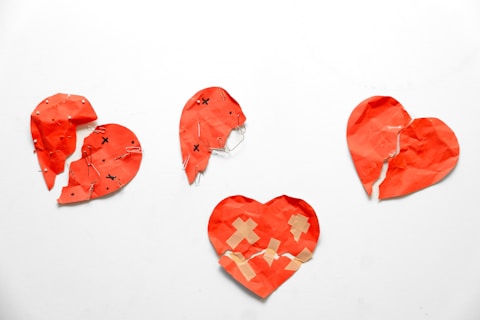 Four red hearts, some broken, one bandaged.