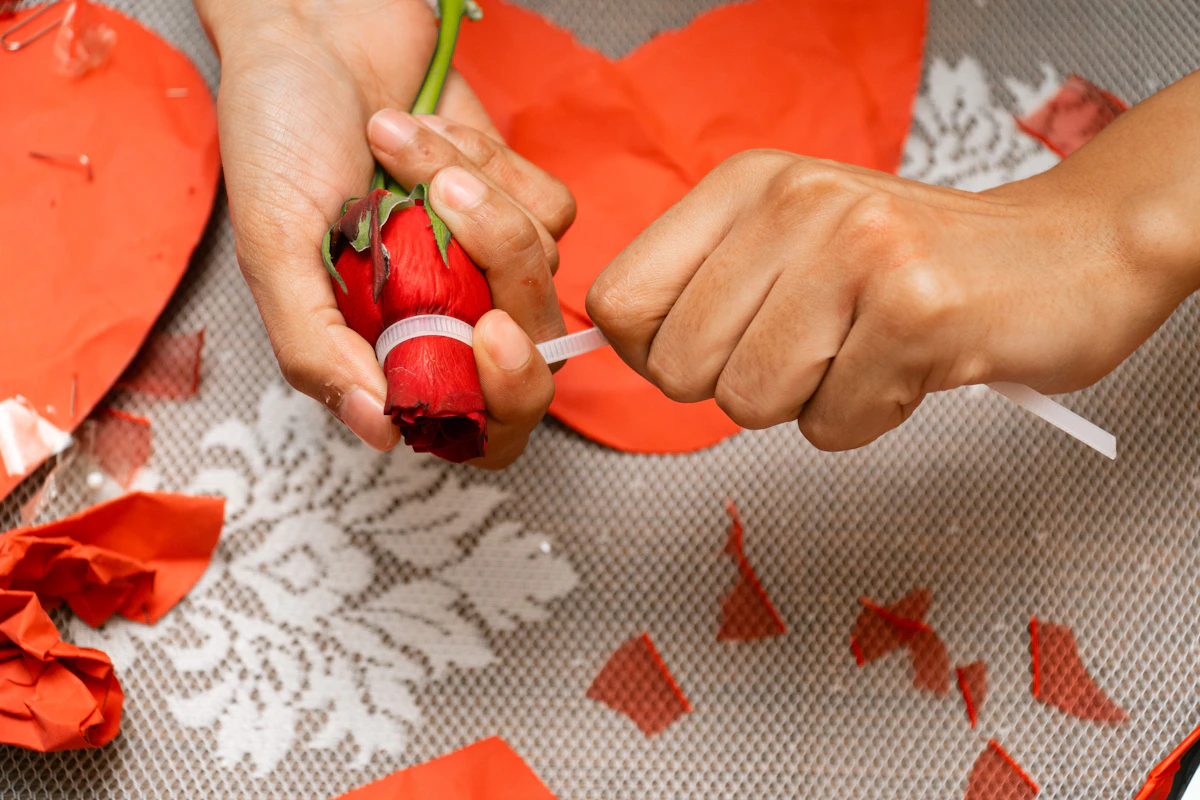 Hands creating a handmade rose gift, representing inexpensive and personal anniversary gifts