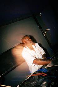 A dj performing at a console with headphones on.