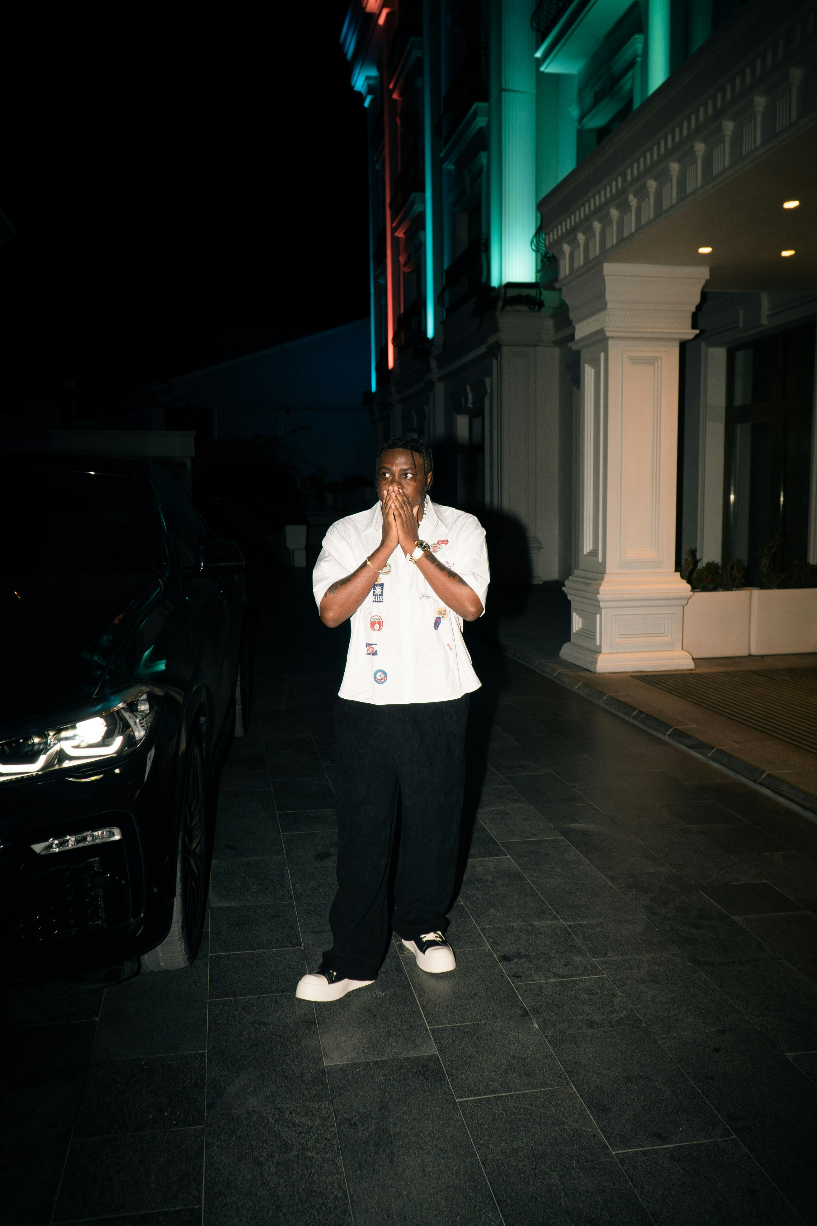 A person stands outside a building at night.