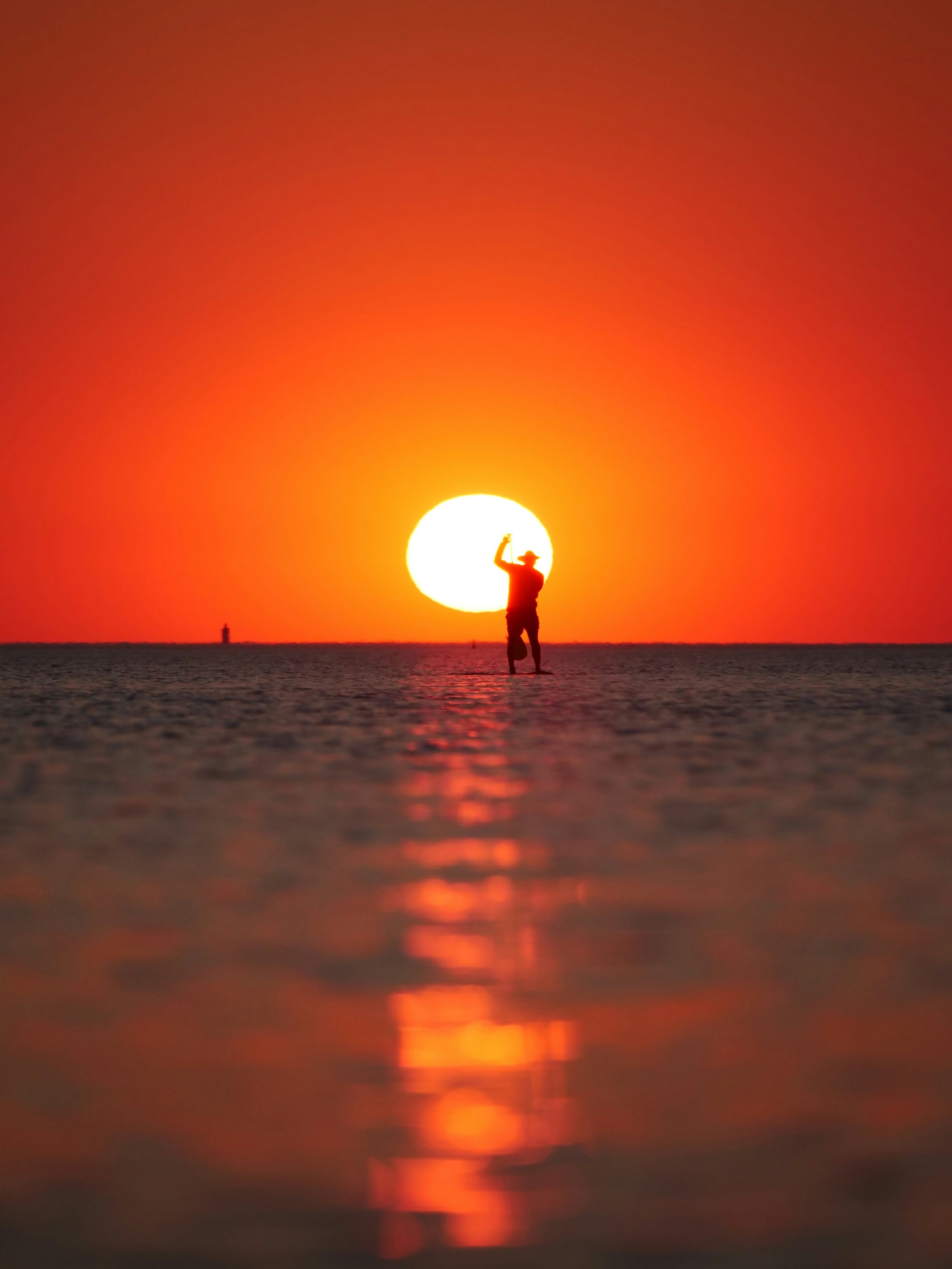 Silhouette of a person on a paddleboard at sunset.