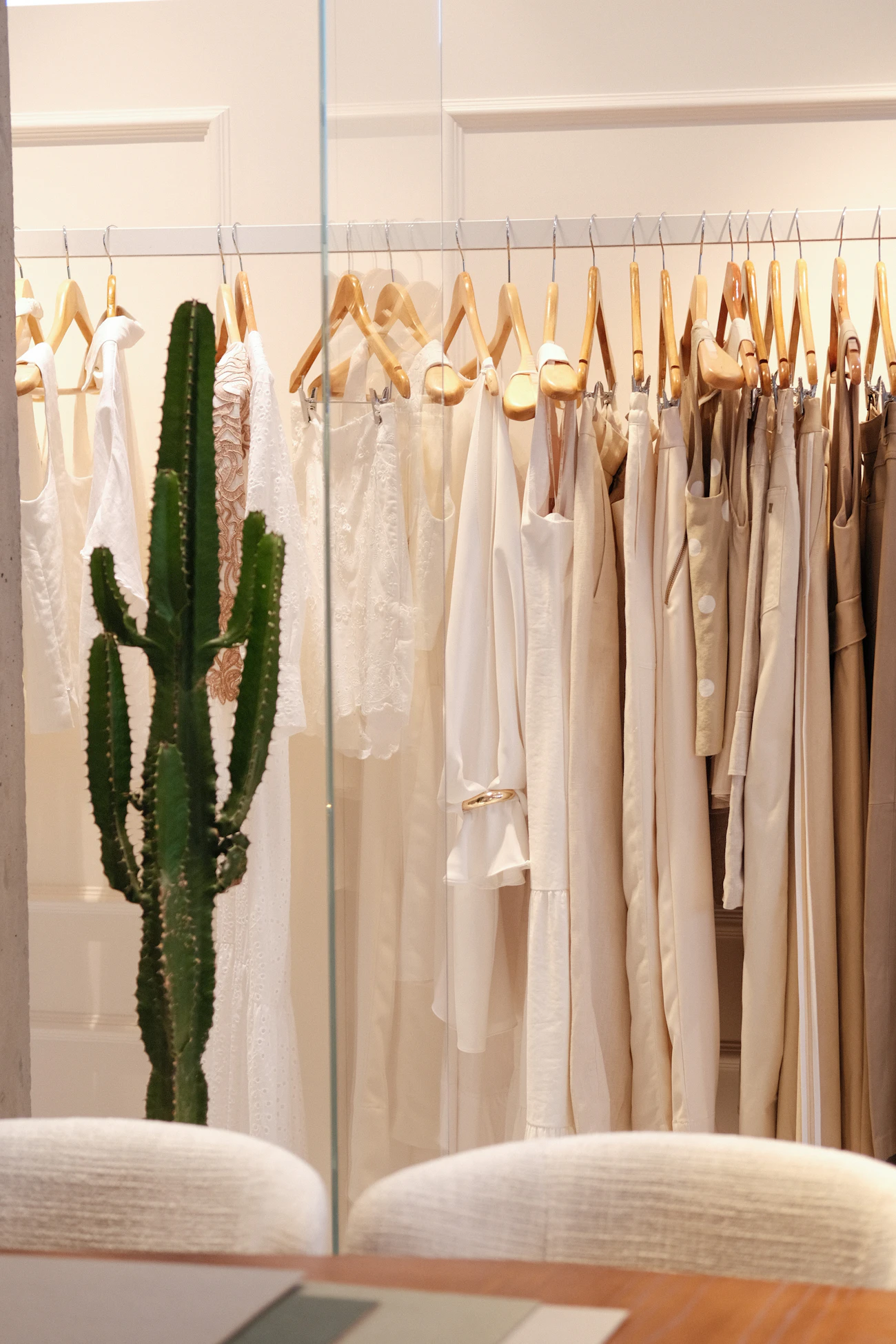 ราวเสื้อผ้าลินินโทนครีมในร้านแสงธรรมชาติ