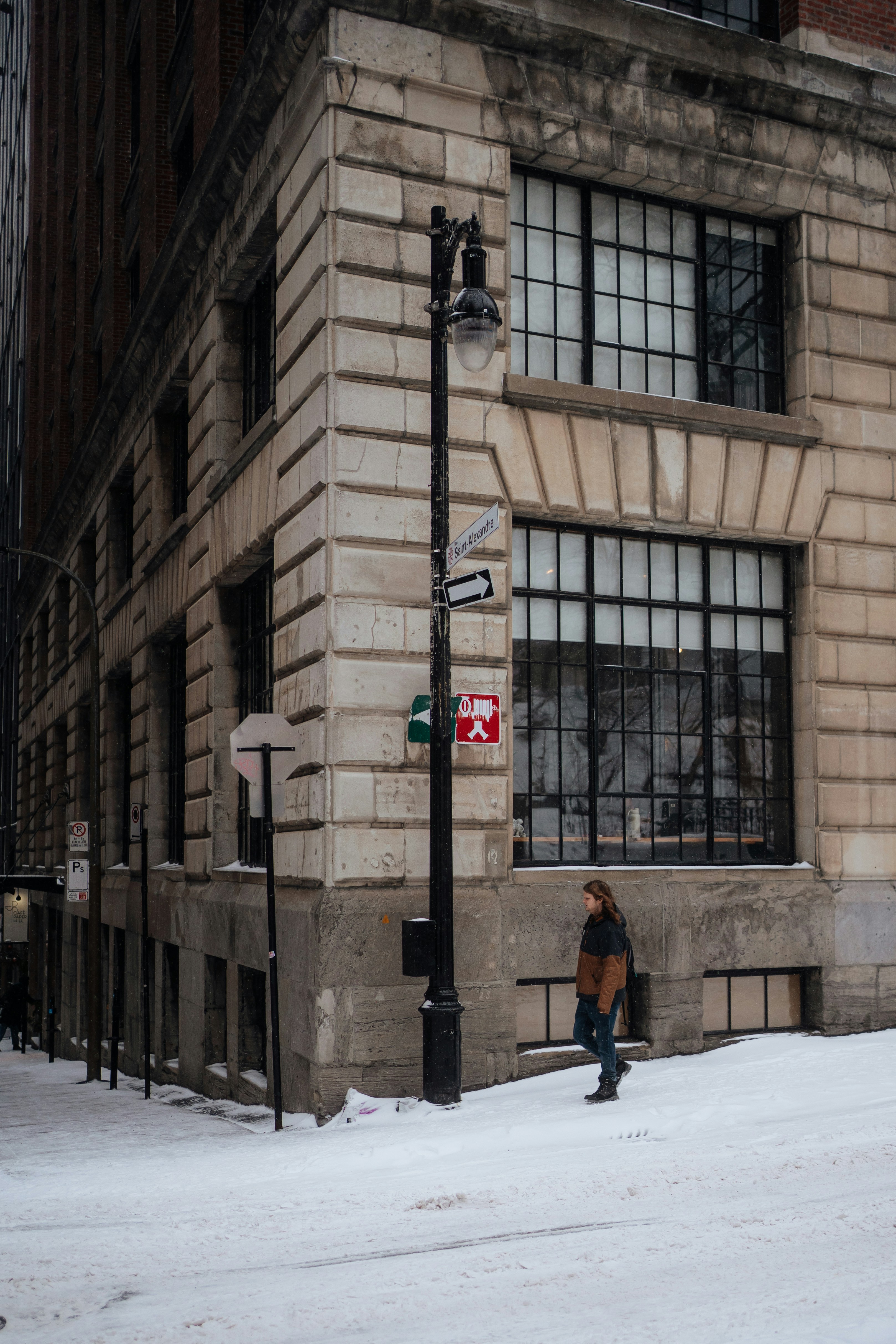 A person walks down a snowy city street.