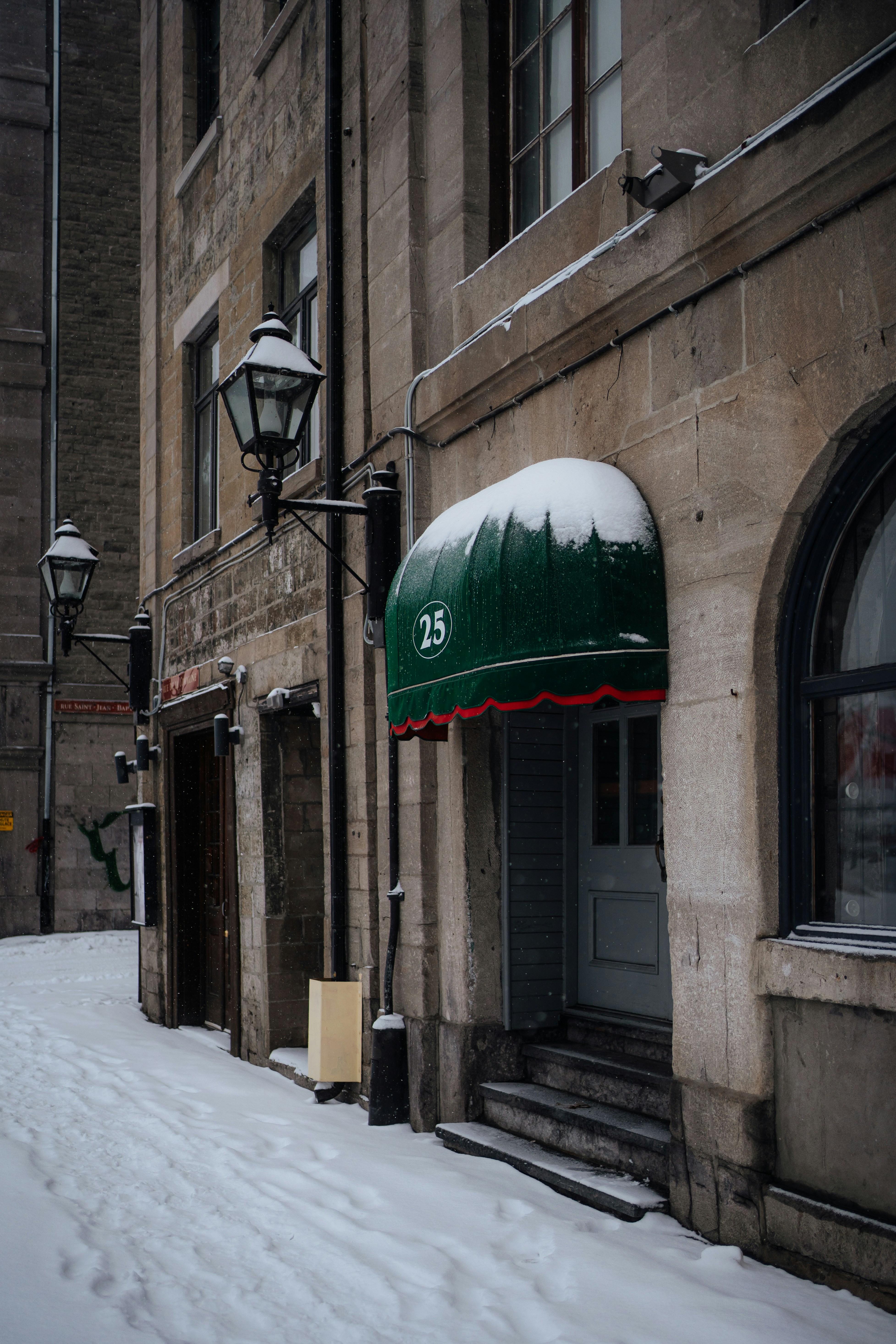 Snowy street with old buildings and green awning