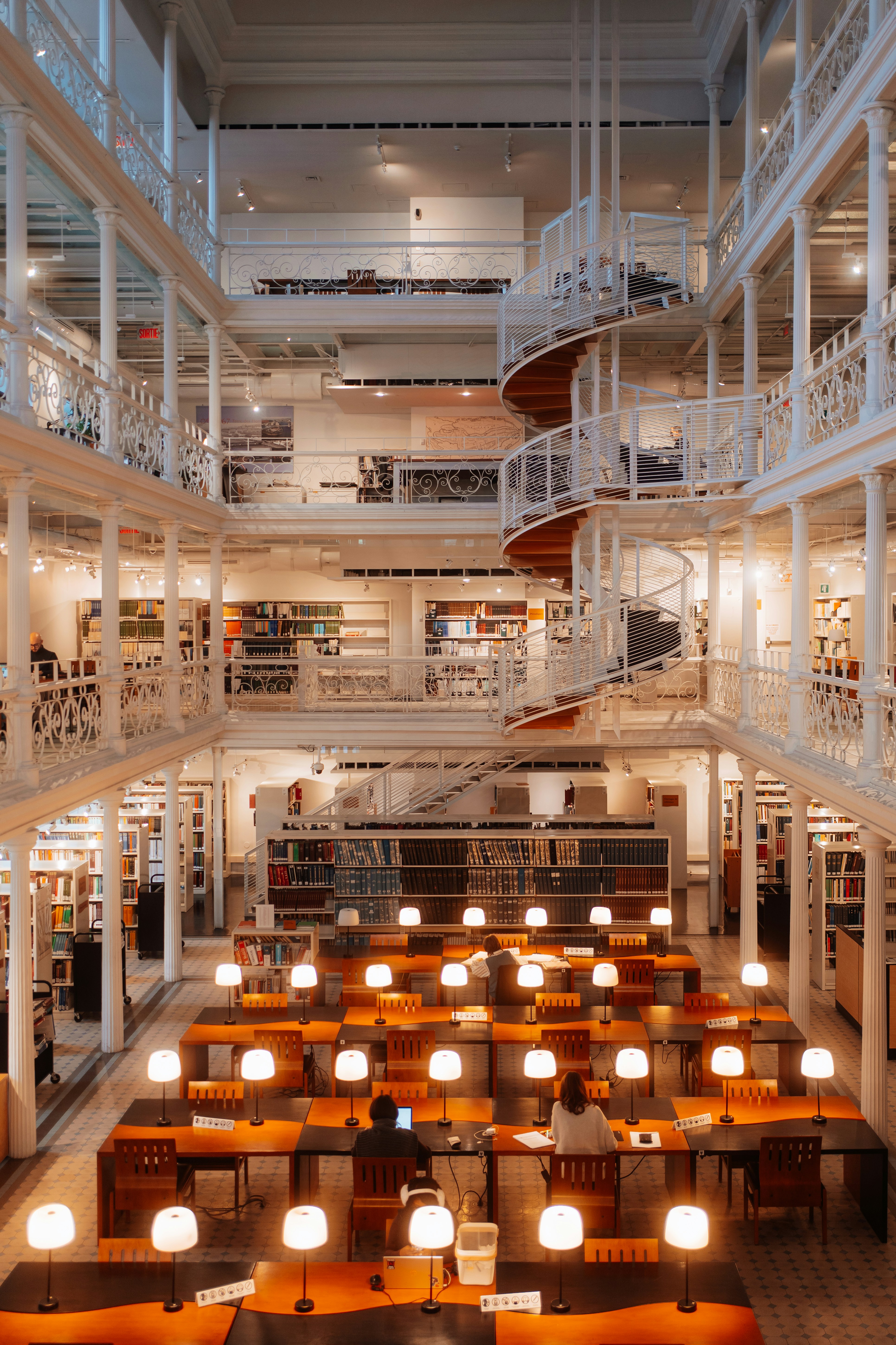 Grand library interior with desks and spiral staircase