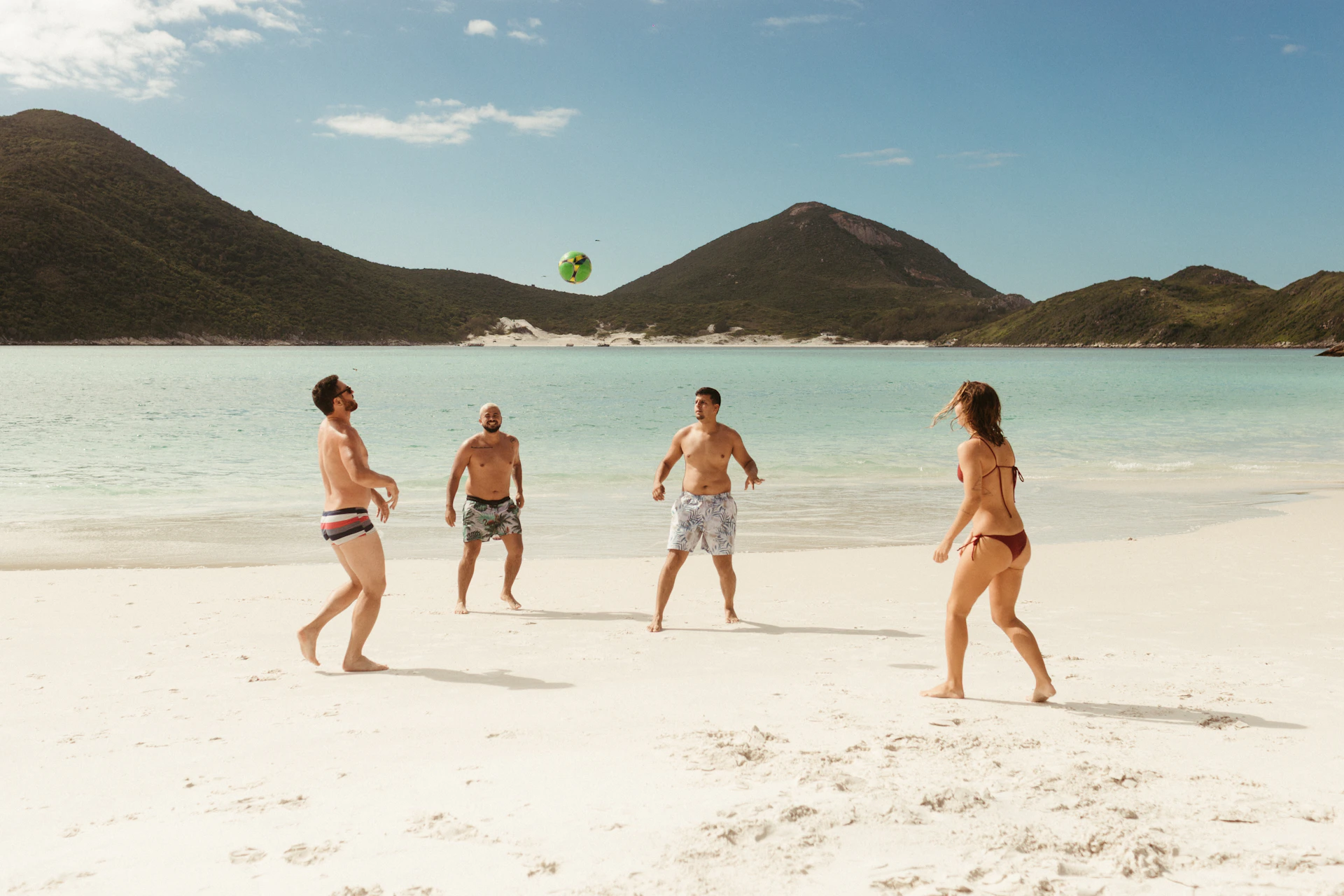 People playing volleyball on a sandy beach