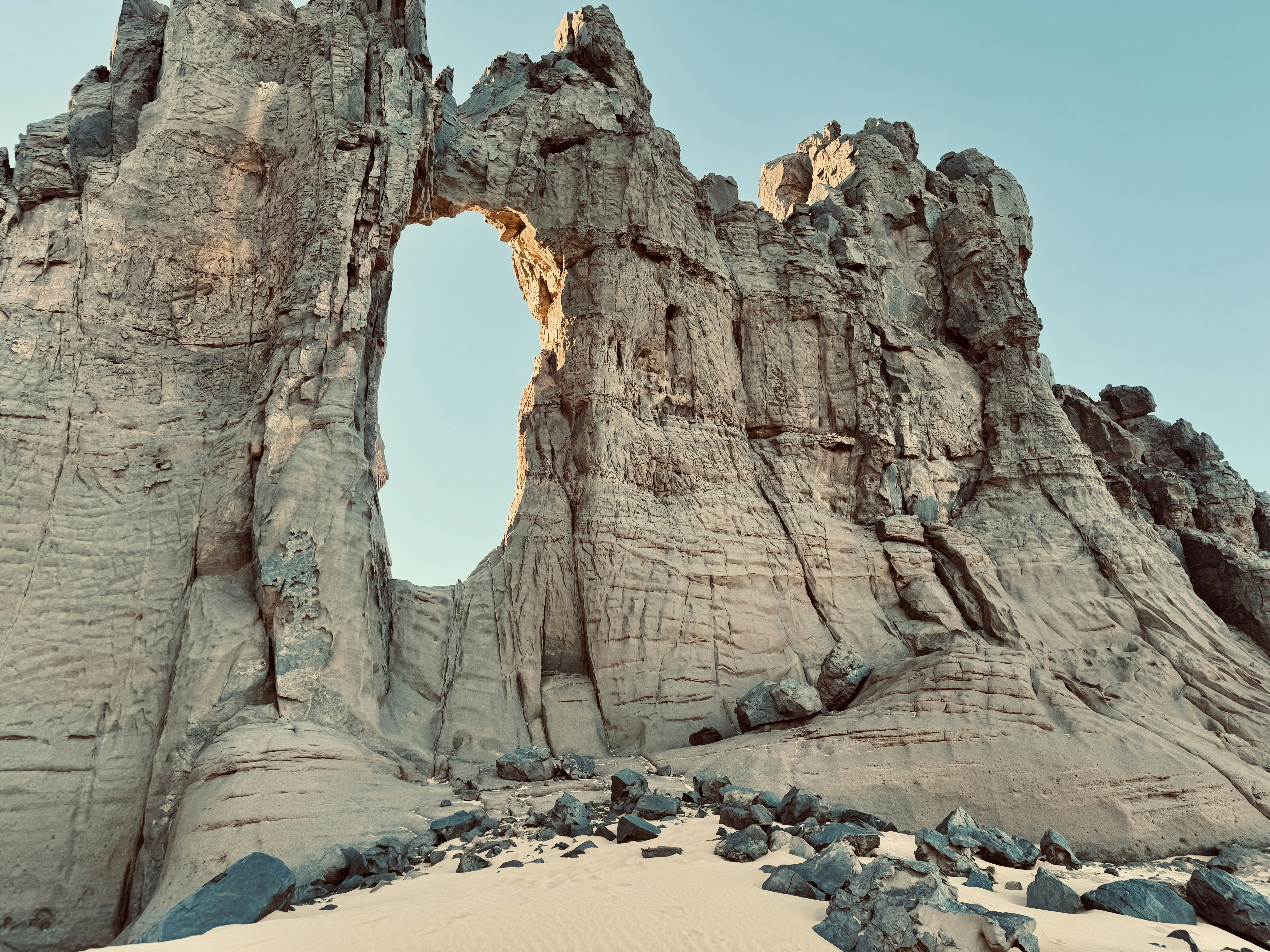 Natural arch rock formation in a desert landscape.