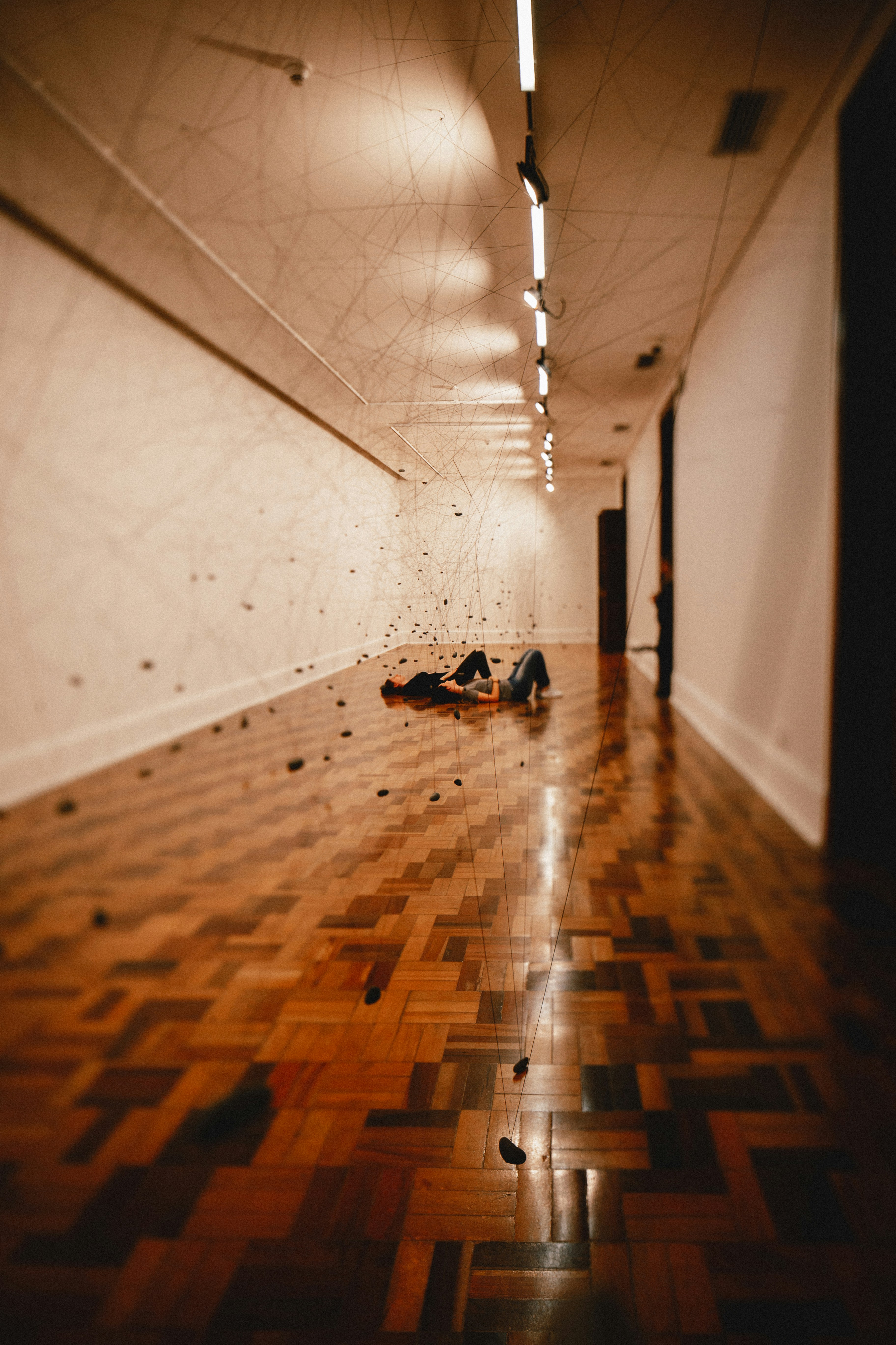 긴 복도 바닥에 두 사람이 누워 있다.