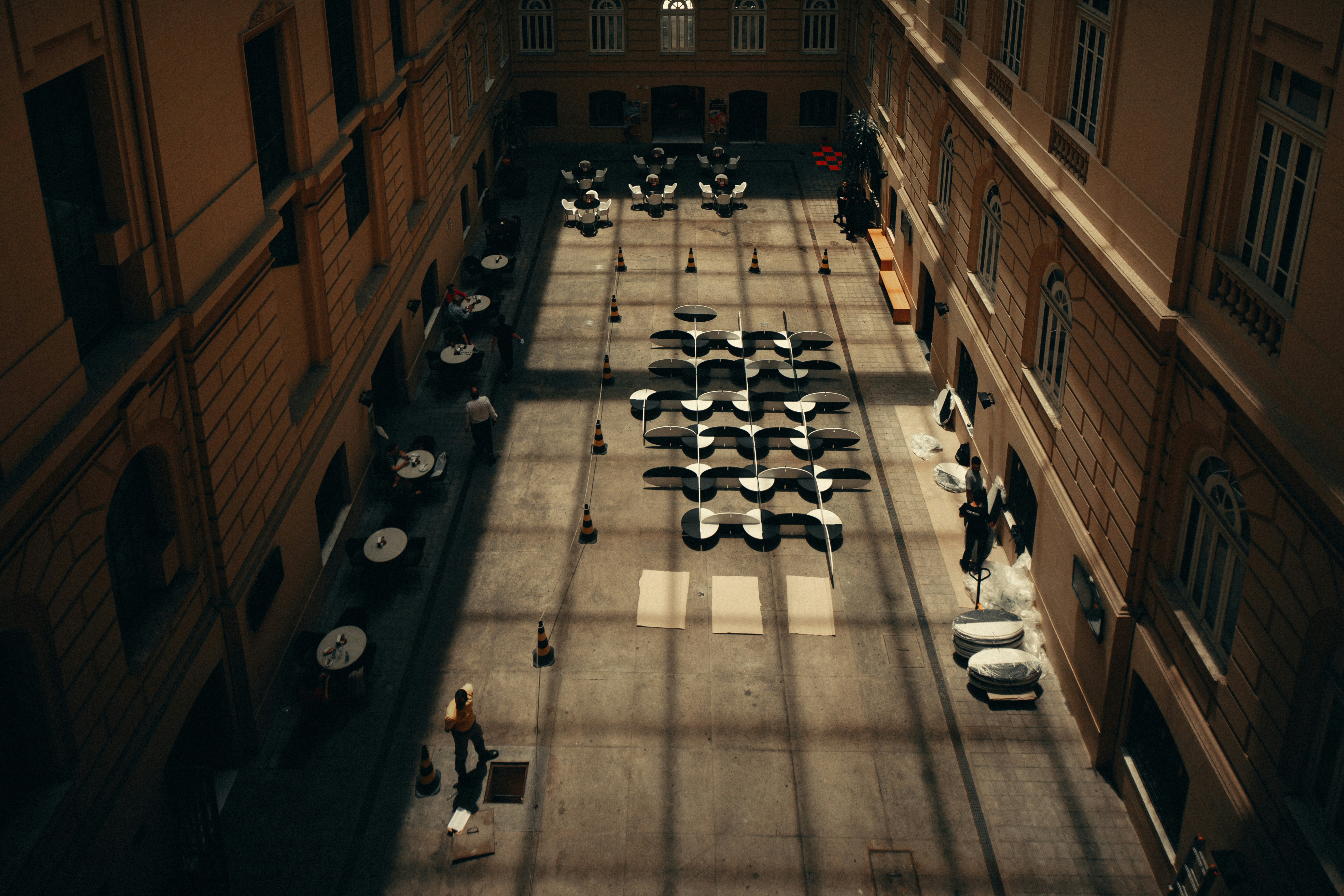 의자가 놓인 안뜰을 걷는 사람들이