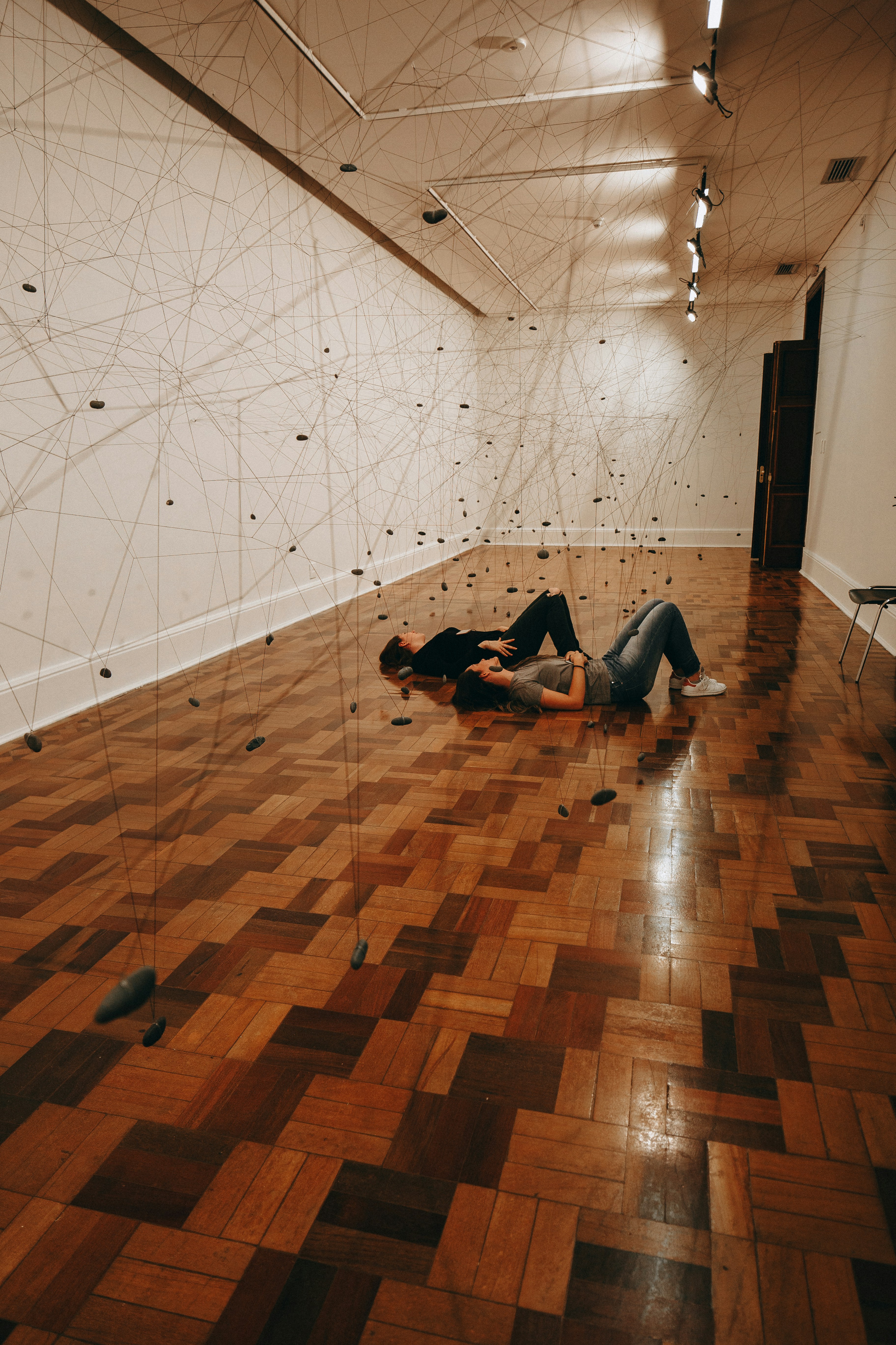 전시 설치 작품 사이에 갤러리 바닥에 누워 있는 두 사람이