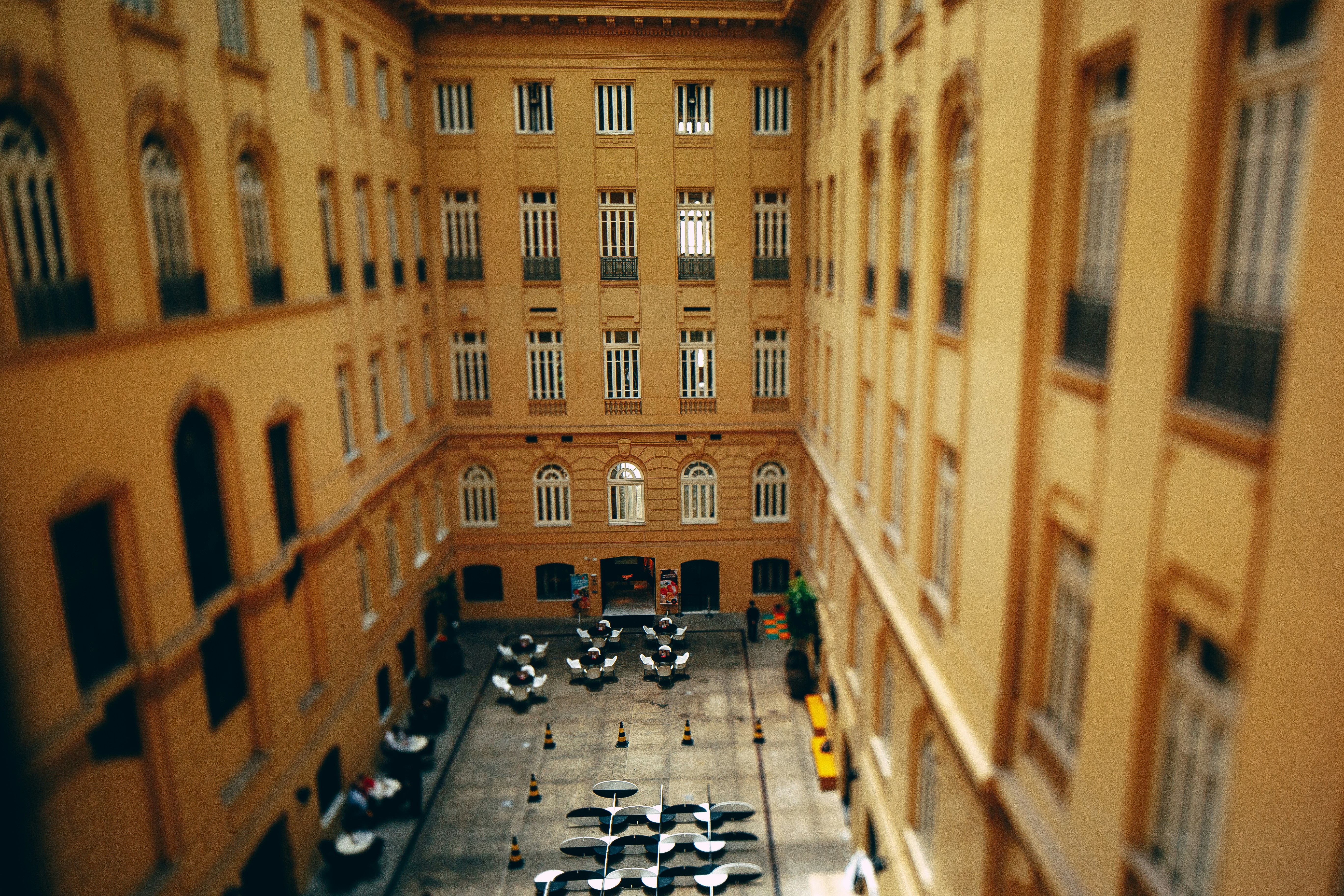 테이블과 의자가 있는 역사적인 건물의 안뜰.