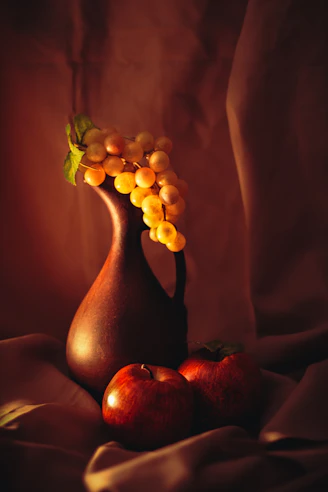 Grapes in a vase with two apples