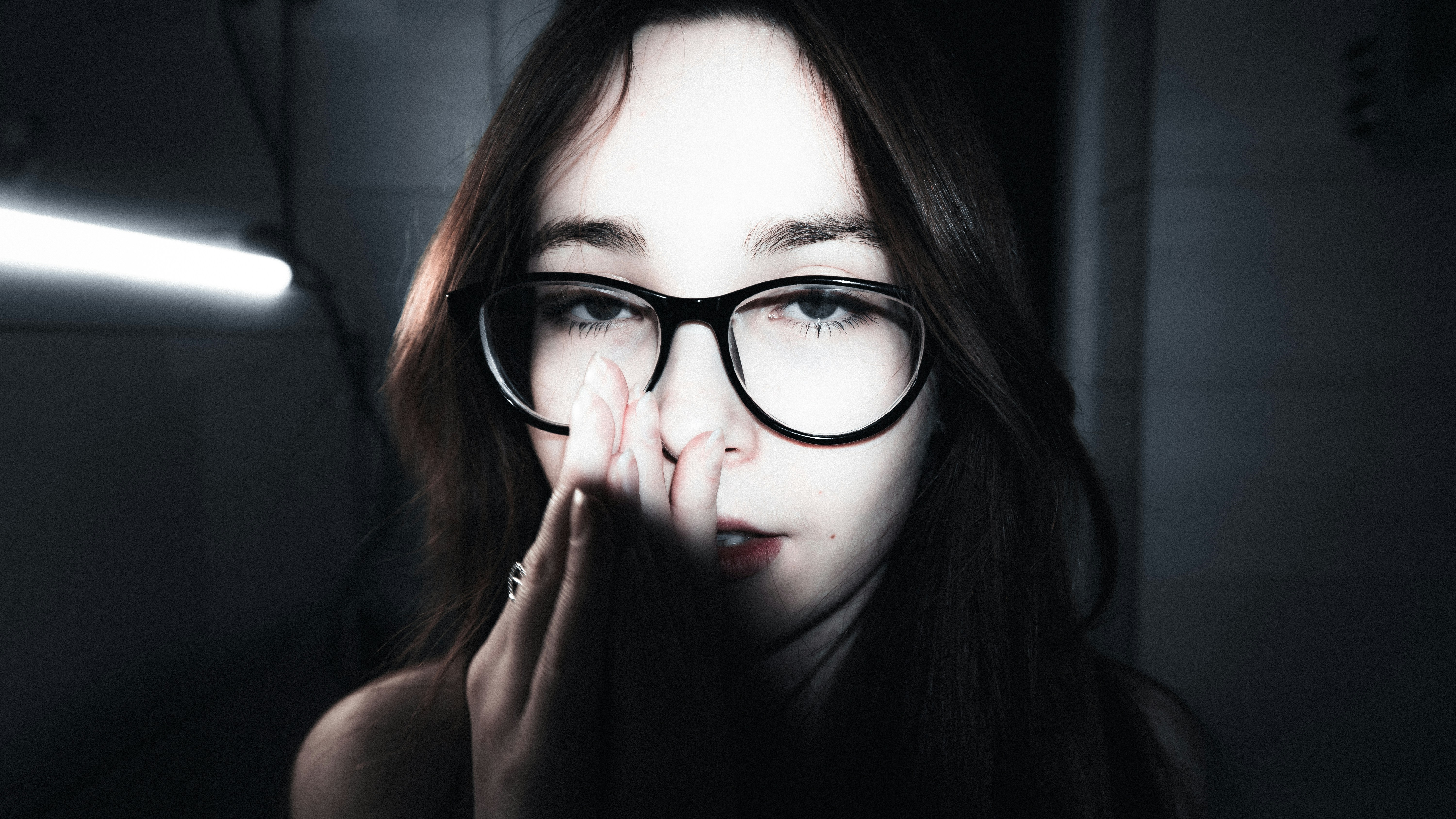 Young woman with glasses covering her face
