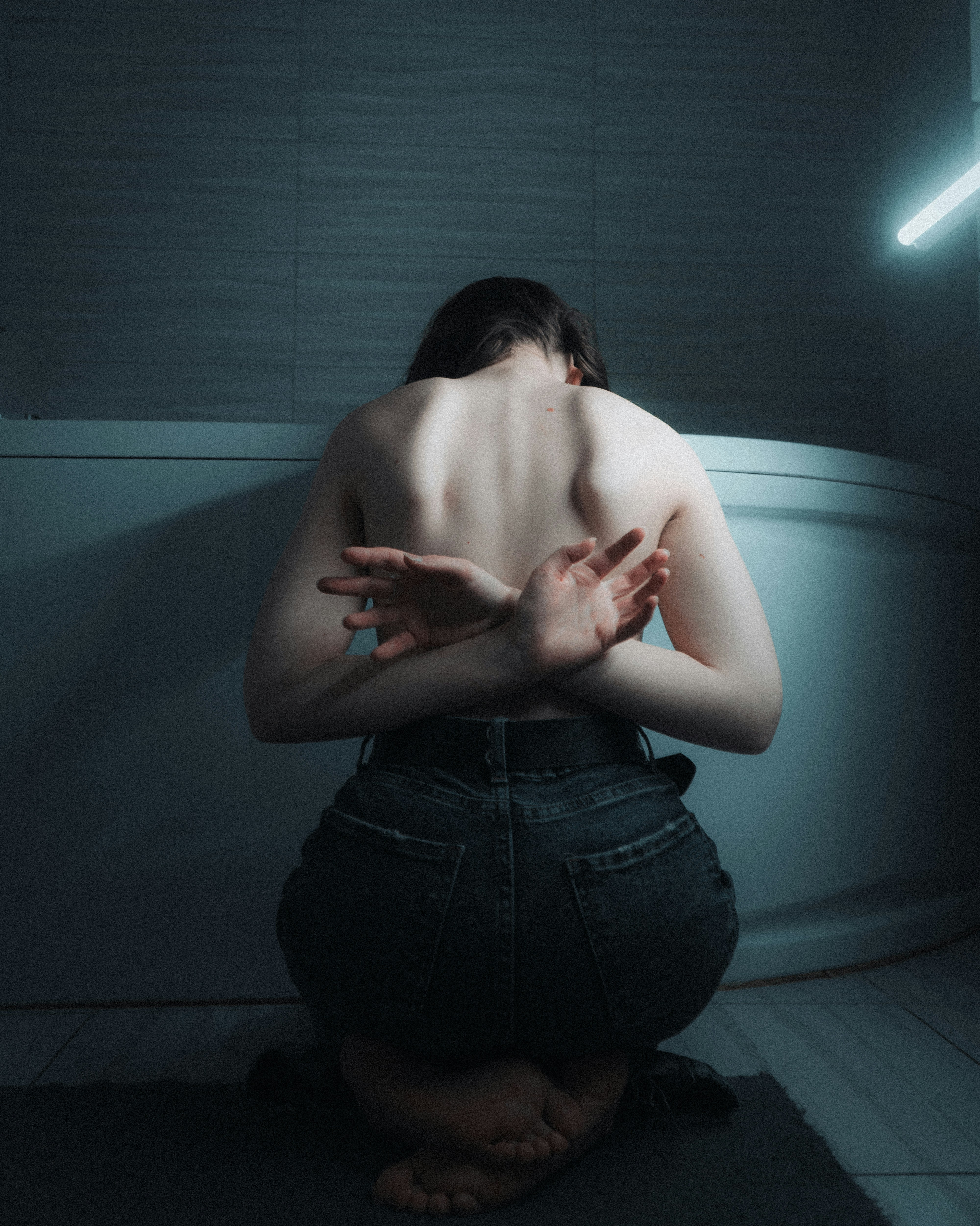 Woman kneeling with hands behind back