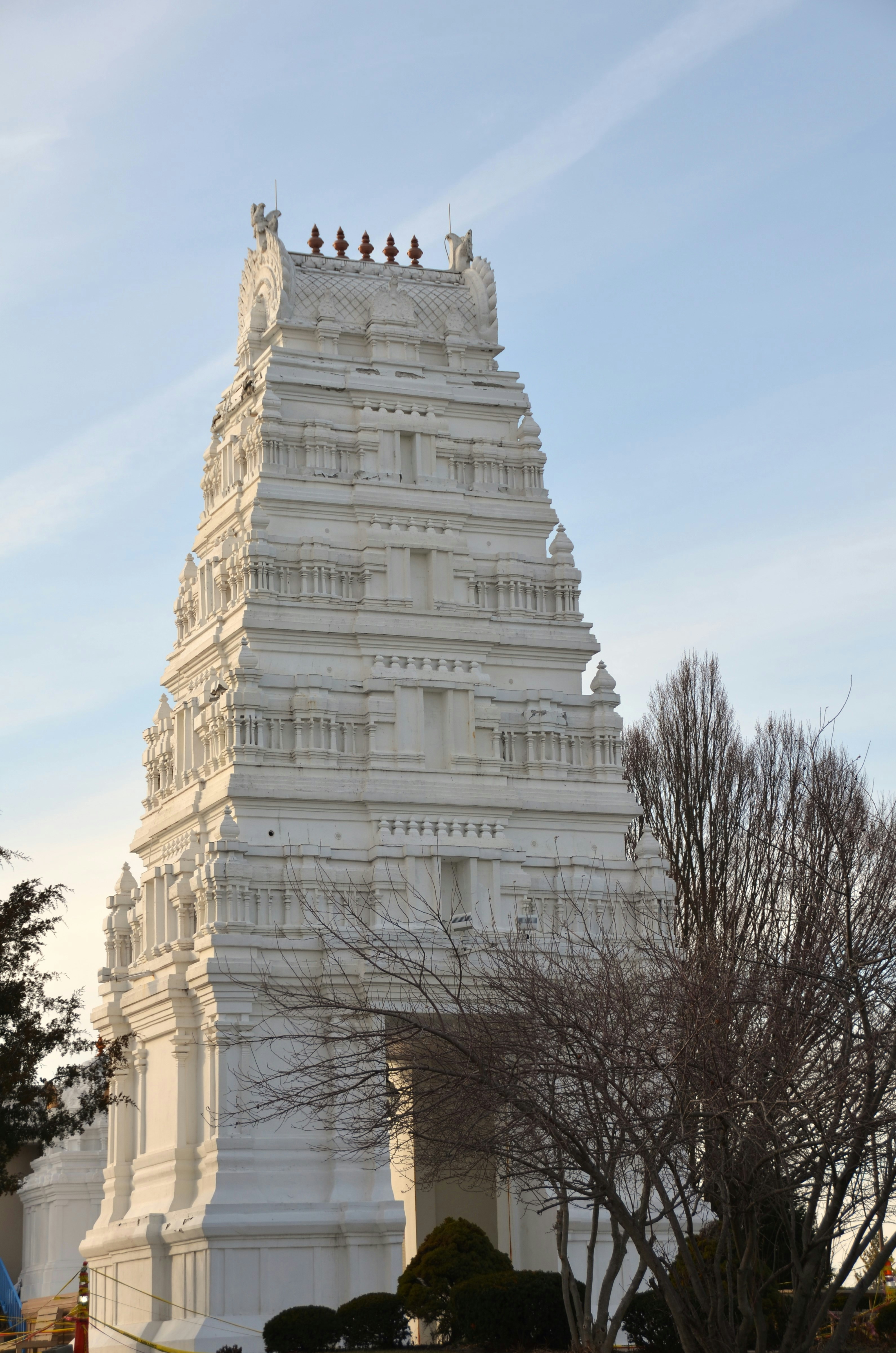 White hindu temple tower against a blue sky.