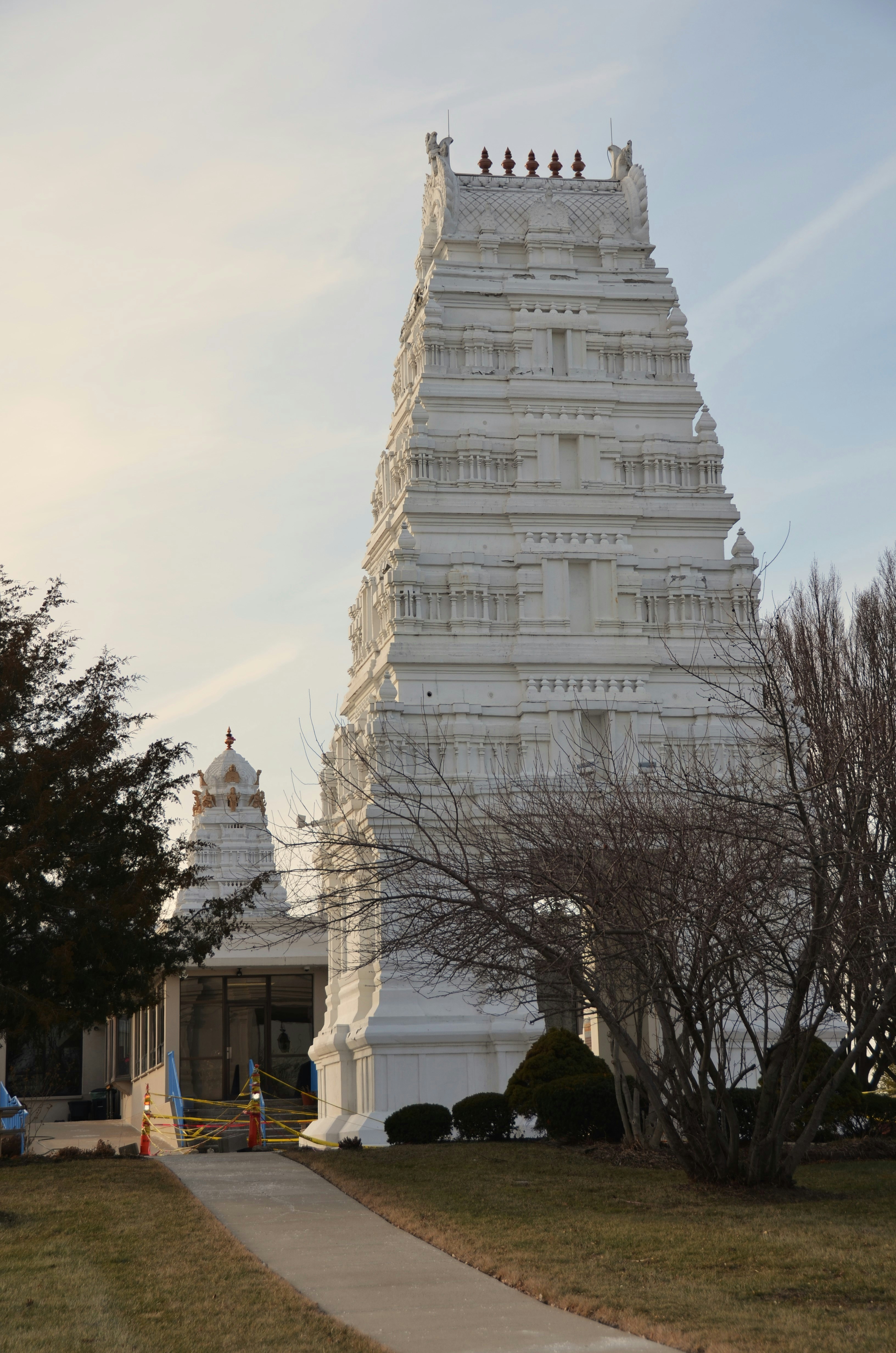 White hindu temple with ornate tower against a blue sky
