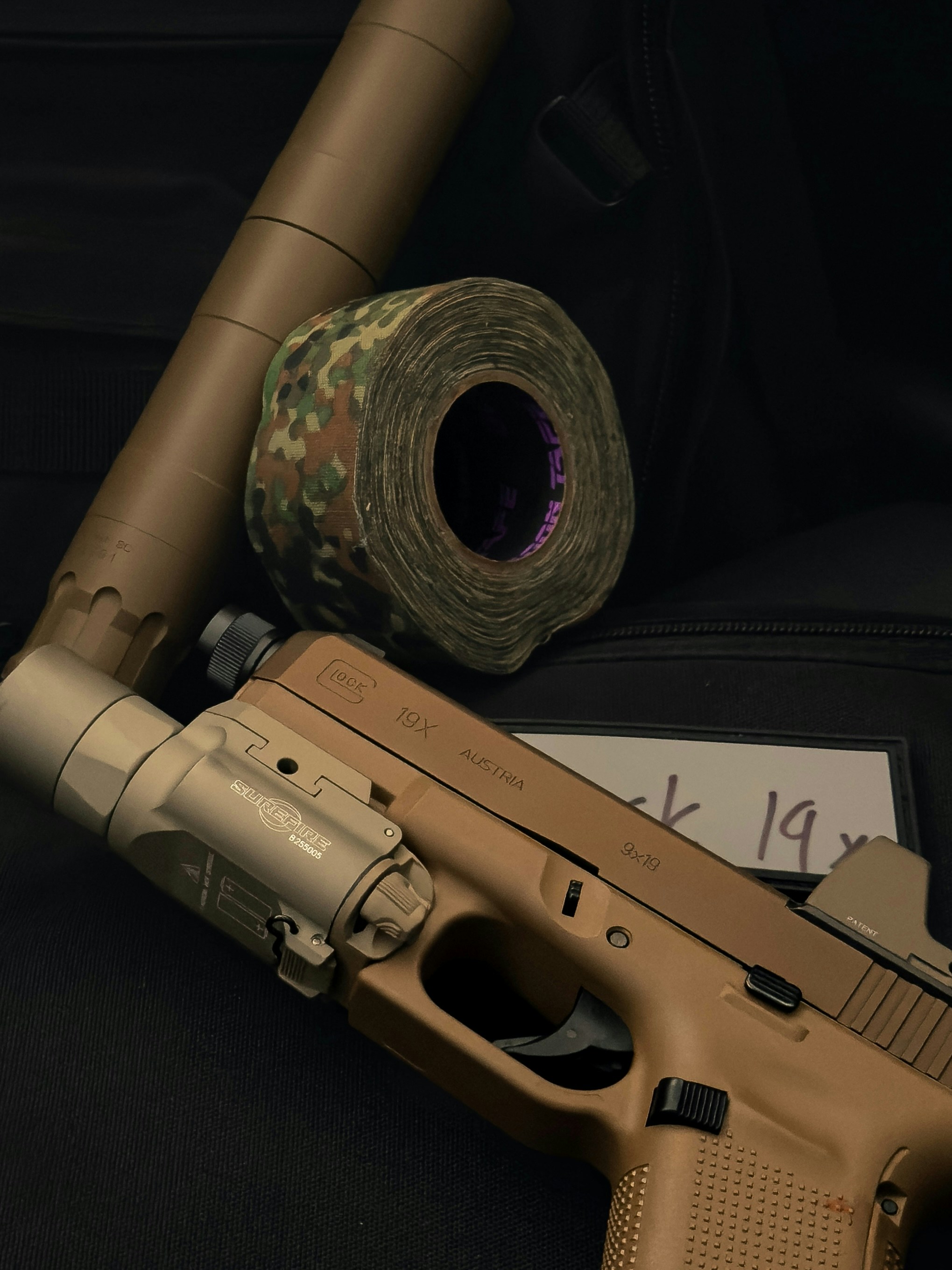 Beige Pistole mit Schalldämpfer und Tarnband