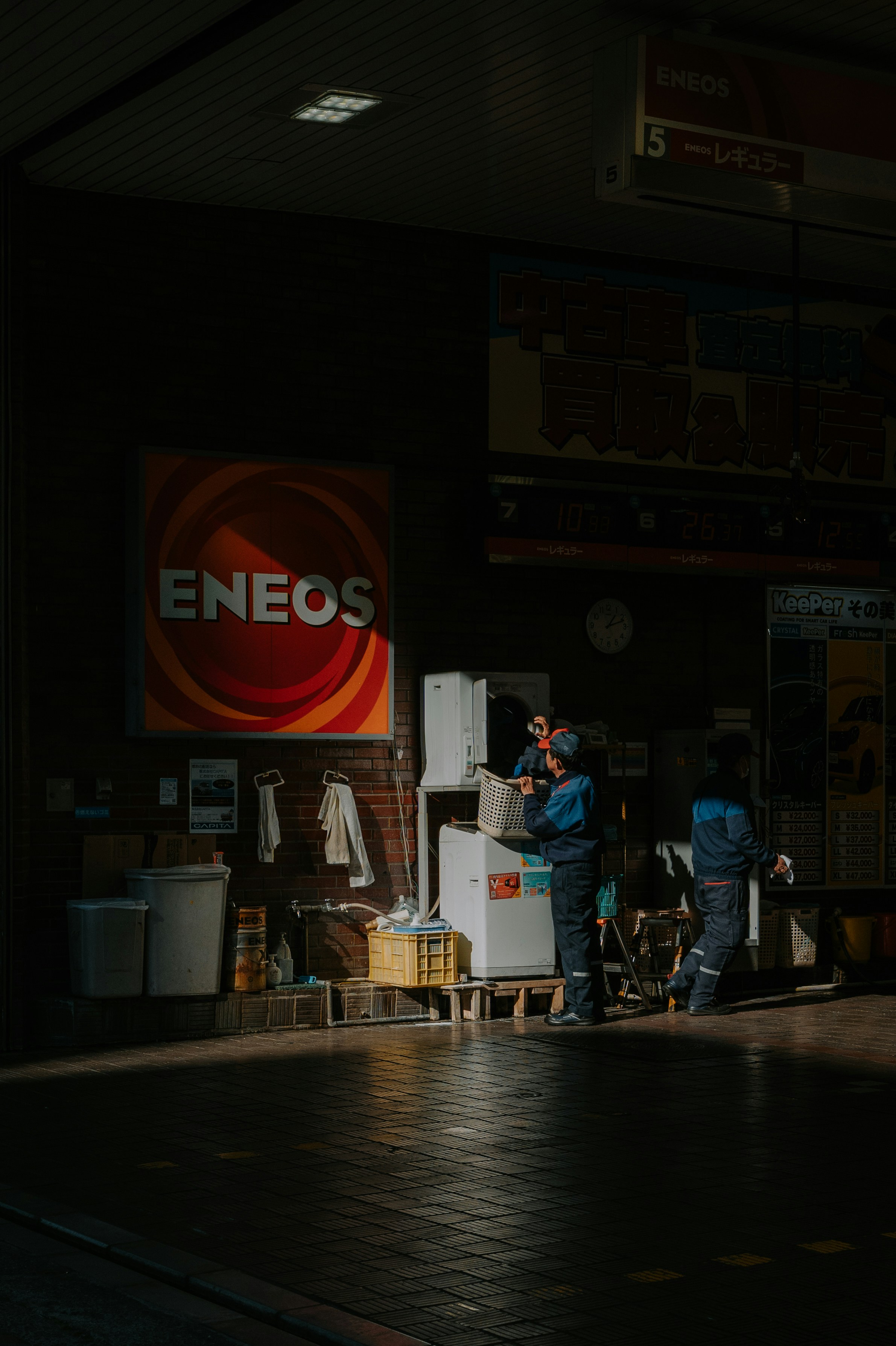 Lavoratori in divisa blu vicino al cartello di Enos