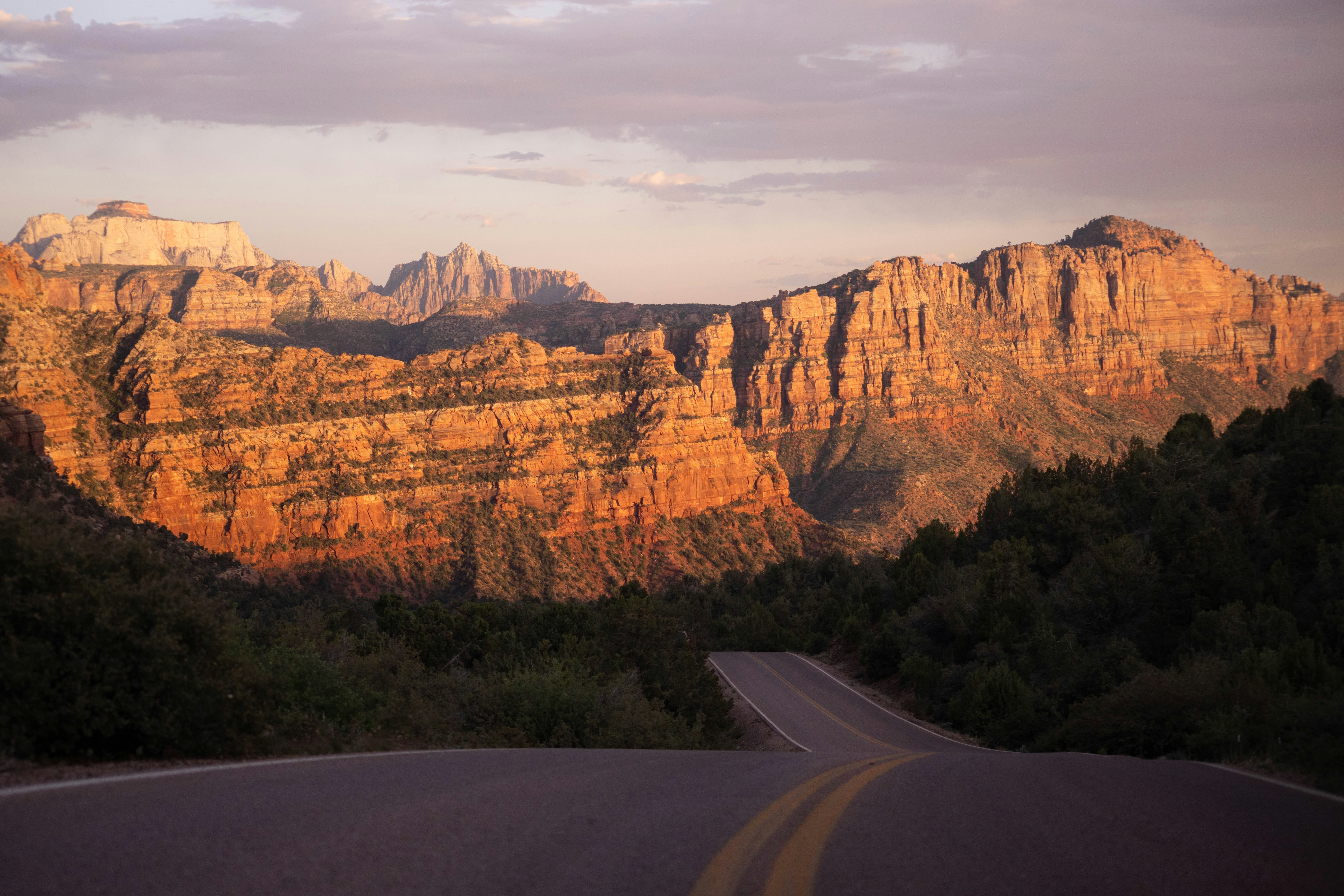 Road leading to majestic mountains at sunset
