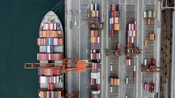 Cargo ship loaded with colorful containers at a busy port.