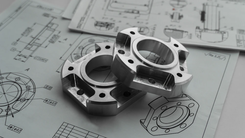Pièces usinées posées sur des plans techniques