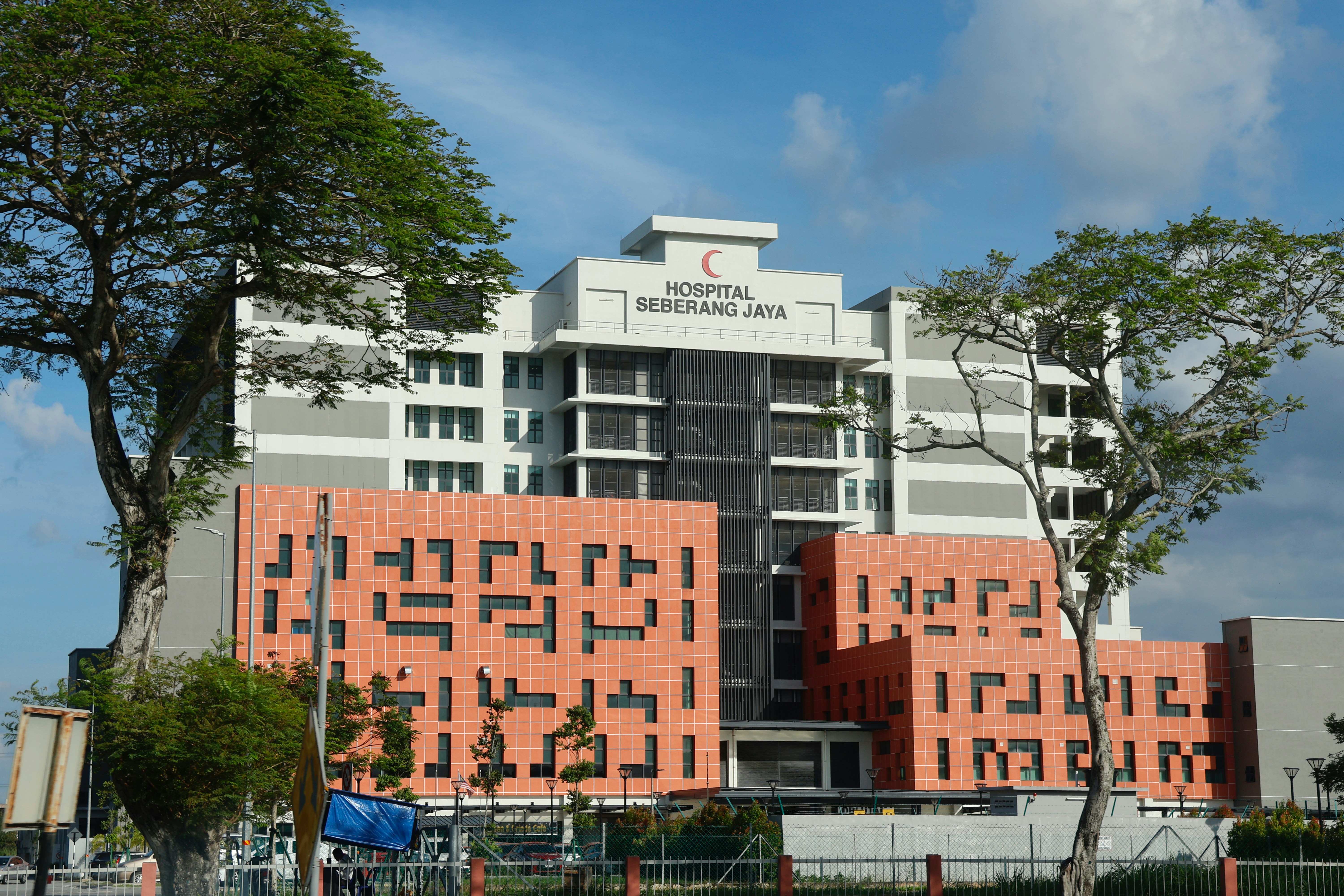 Modern hospital building with red crescent logo.